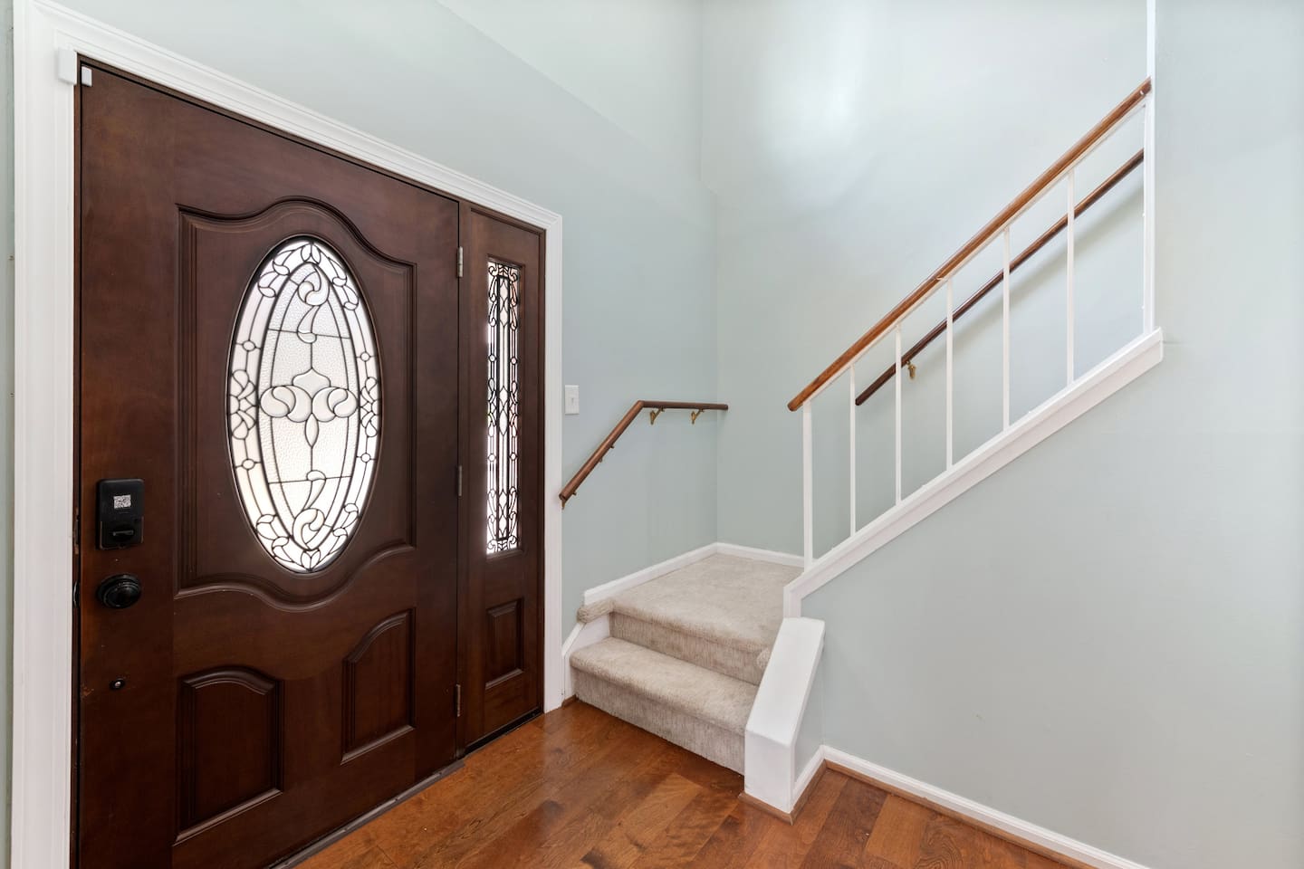 The welcoming entryway features rich wood tones, natural light, and easy flow into the rest of the home.