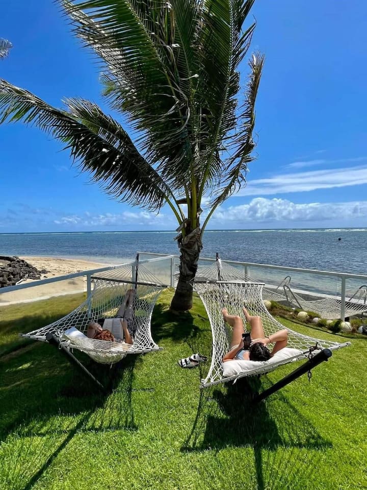 Your own two-person double capacity hammock to smells and listen to the melodious waves. Guests of home in the background in the ocean are standing in the waist-deep crystal-clear water of the snorkeling reef.