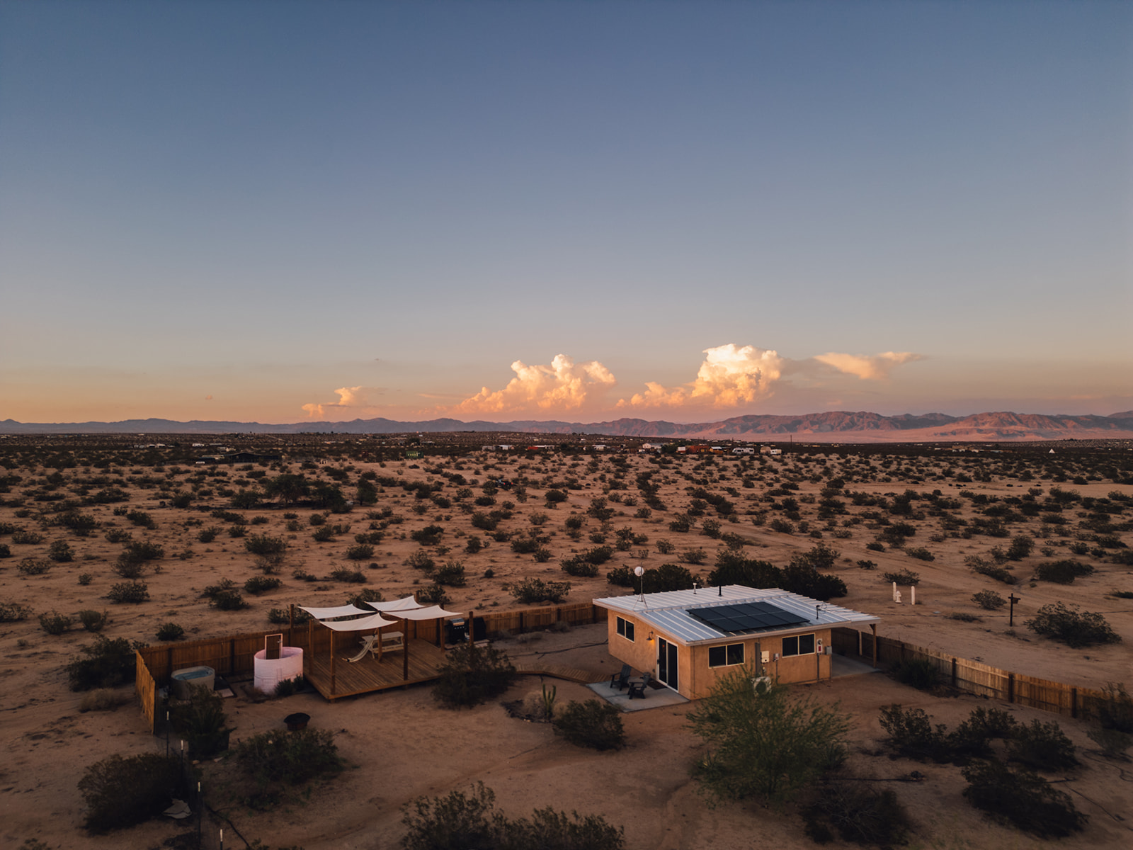 Aerial view of Pink Moon cabin nestled on 2.5 acres of private desert land with panoramic mountain and Joshua Tree vistas.