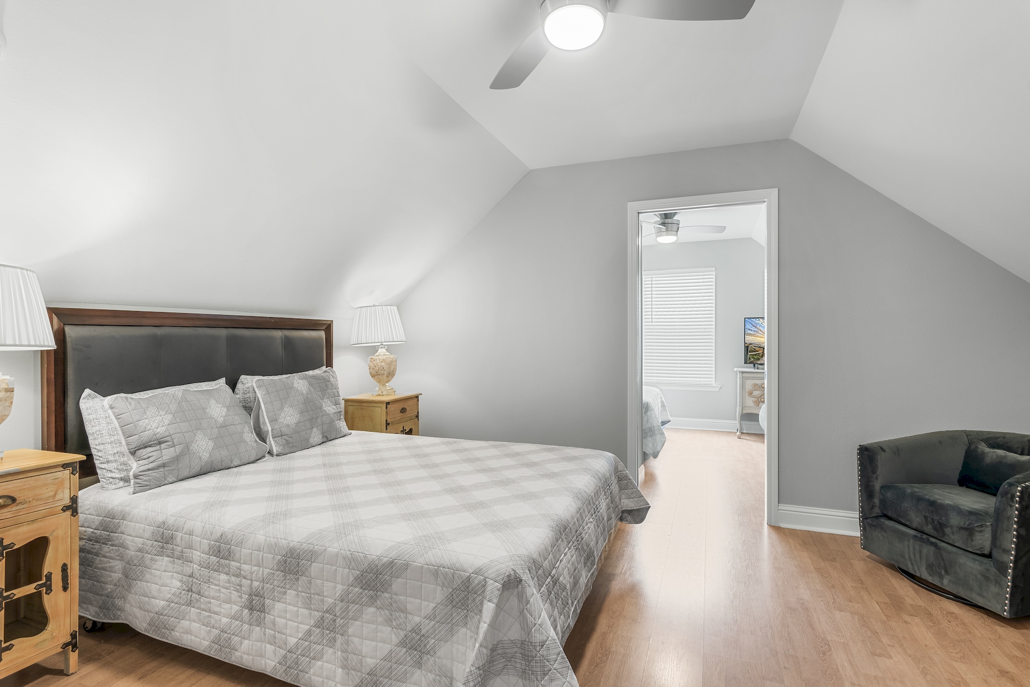 Guest king bedroom with cozy bedding and vaulted ceiling