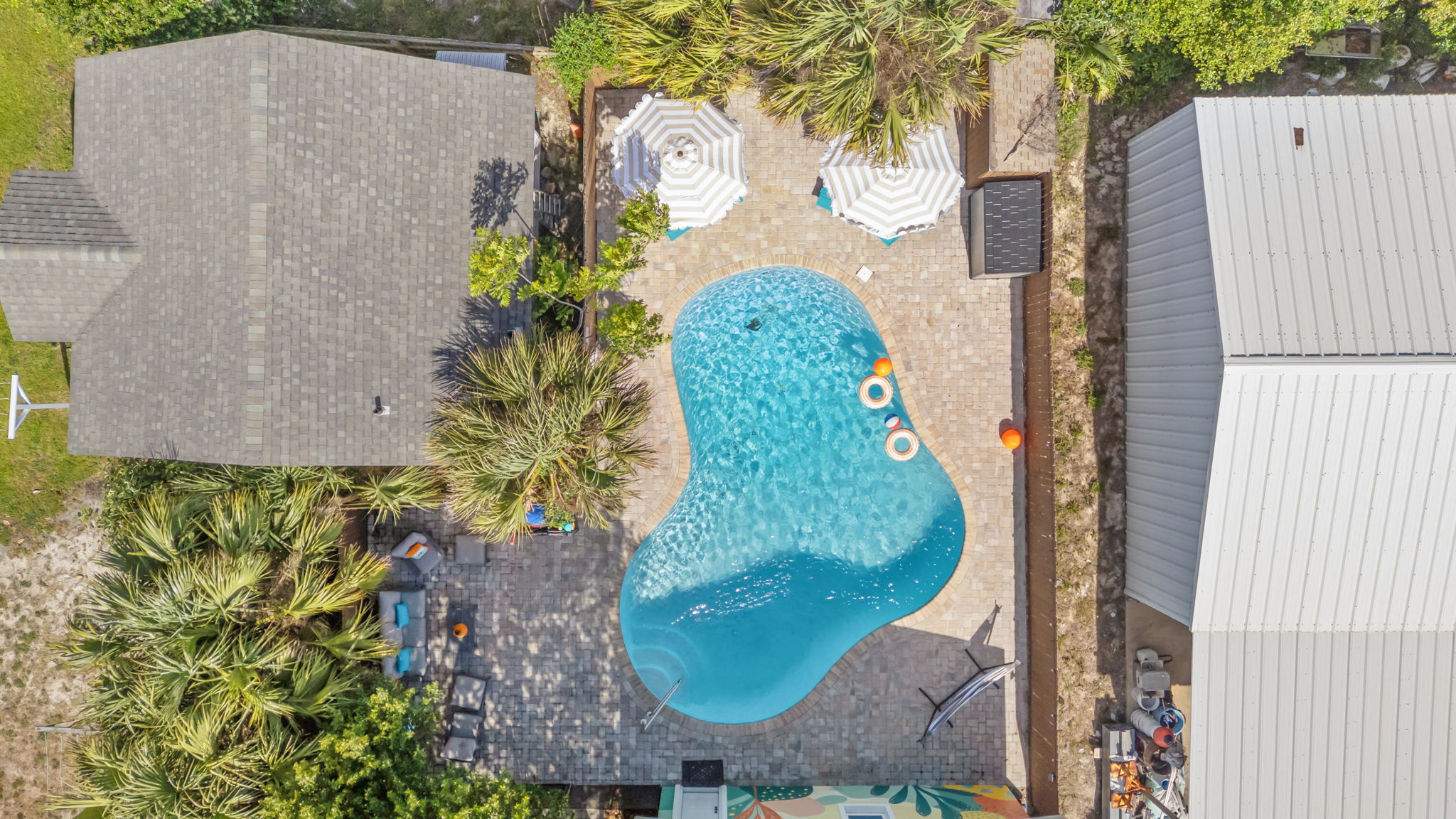 Your private pool from above! The kidney-shaped swim area, patio umbrellas, and surrounding deck invite all-day outdoor living from
sunrise to sunset.