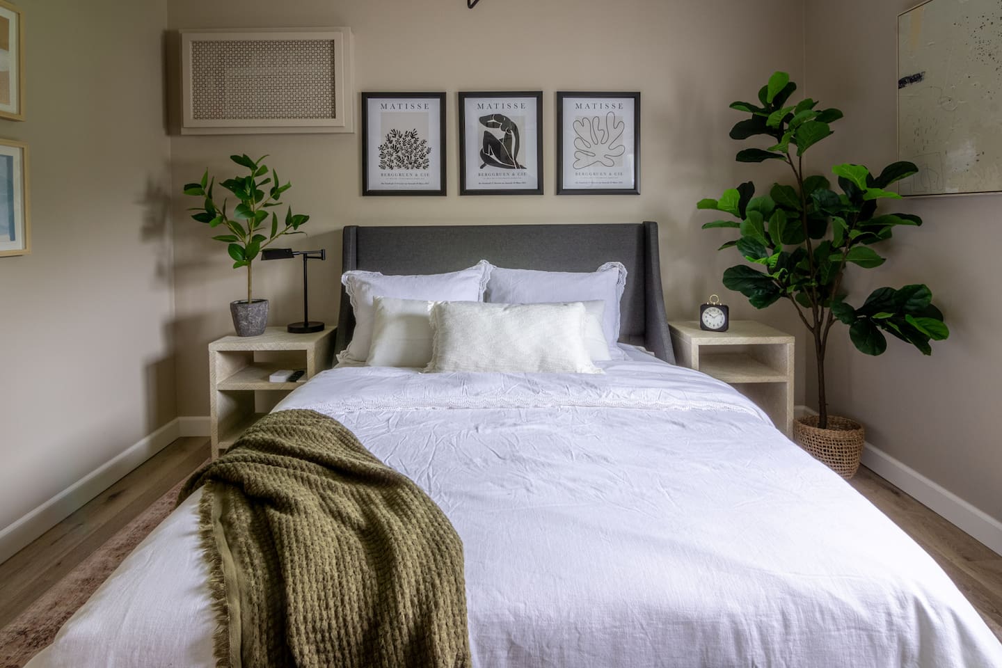 Framed botanical prints and a cozy knit throw give this bedroom a relaxed, layered feel.