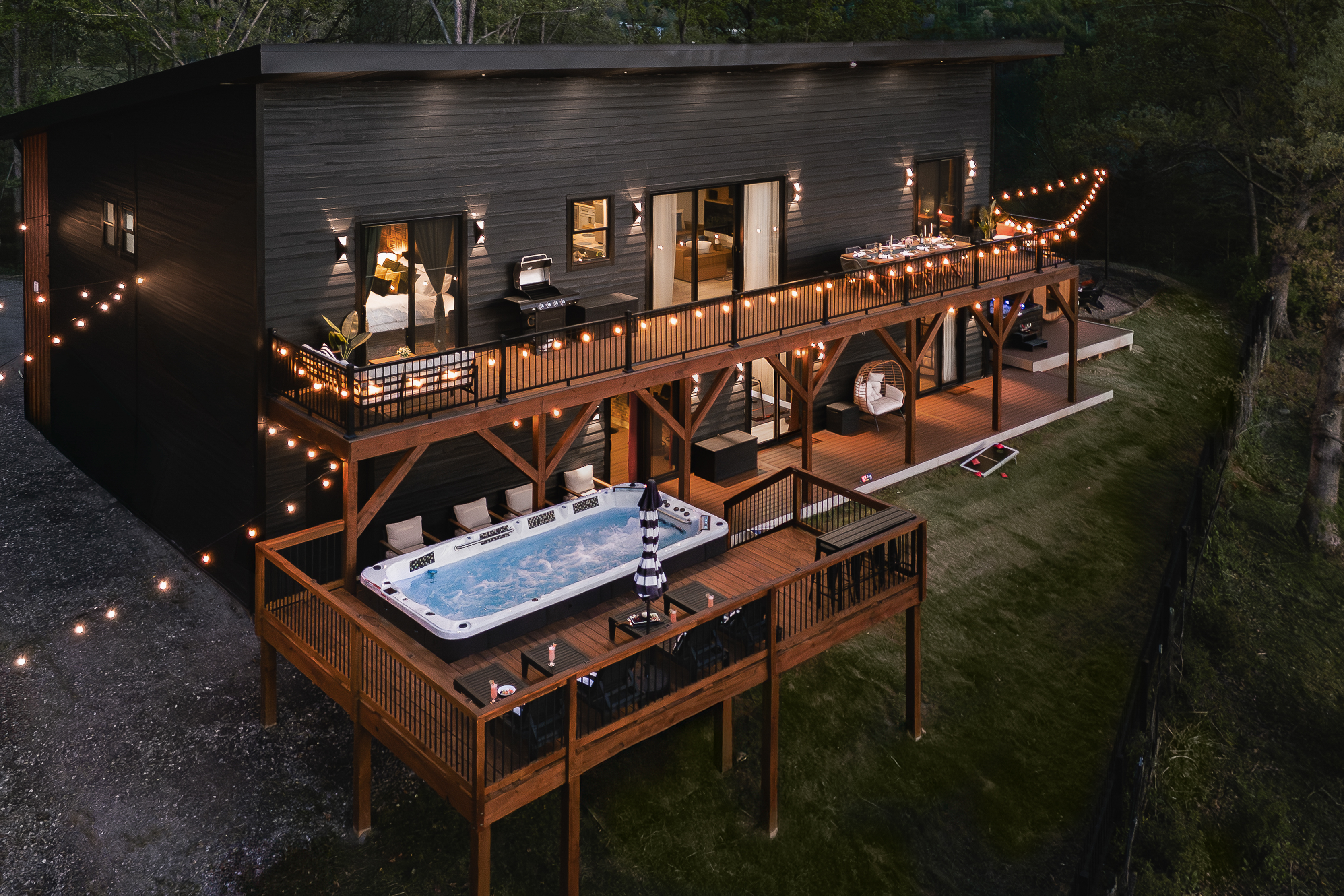 {Welcome} Nighttime at Summit House — soak in the swim spa on the elevated deck beneath glowing string lights, sharing stories over a glass of wine with mountain views all around. The perfect way to unwind and end the night.