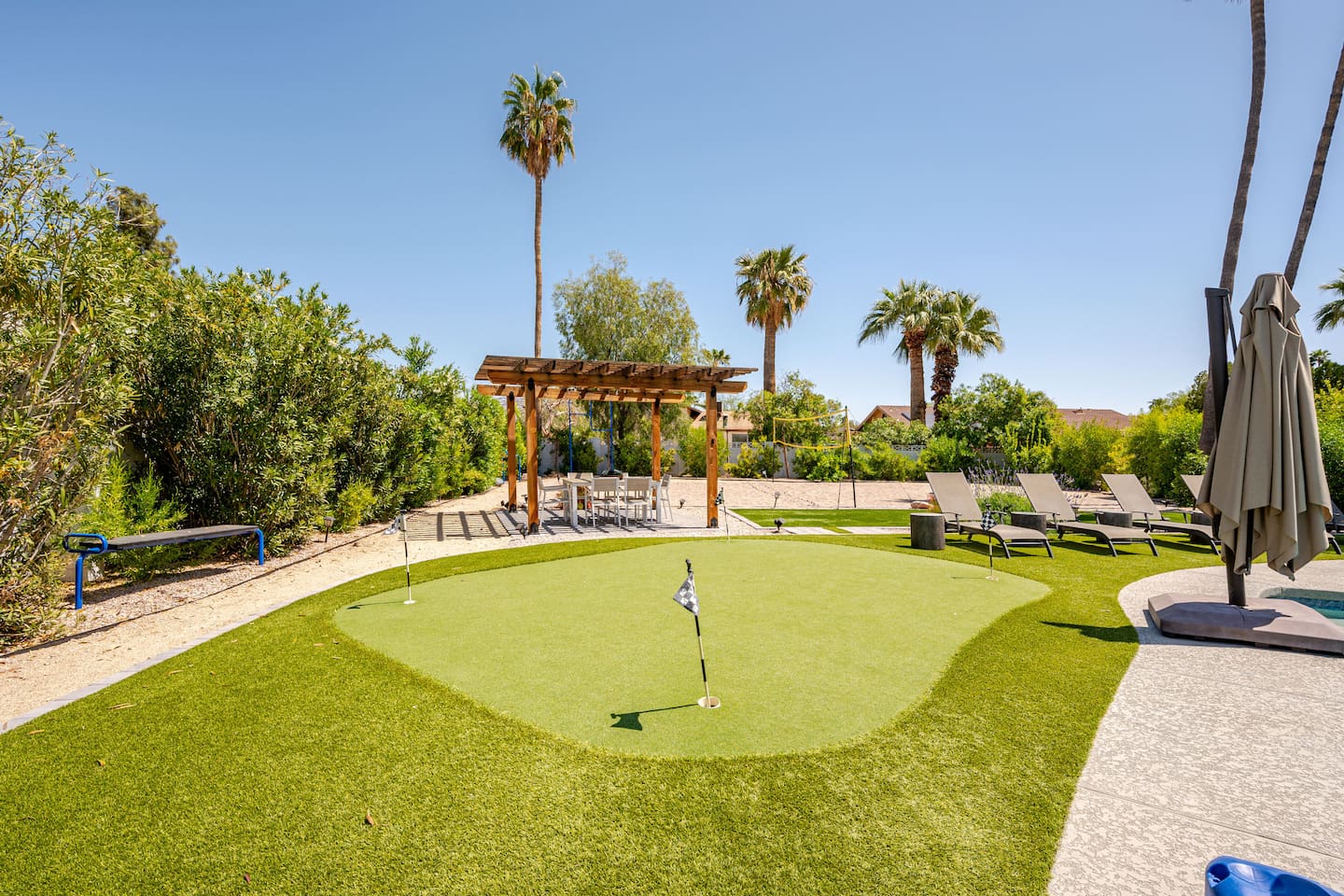 Stunning desert palms surround the putting green and pergola dining area, creating a beautiful setting for outdoor memories.