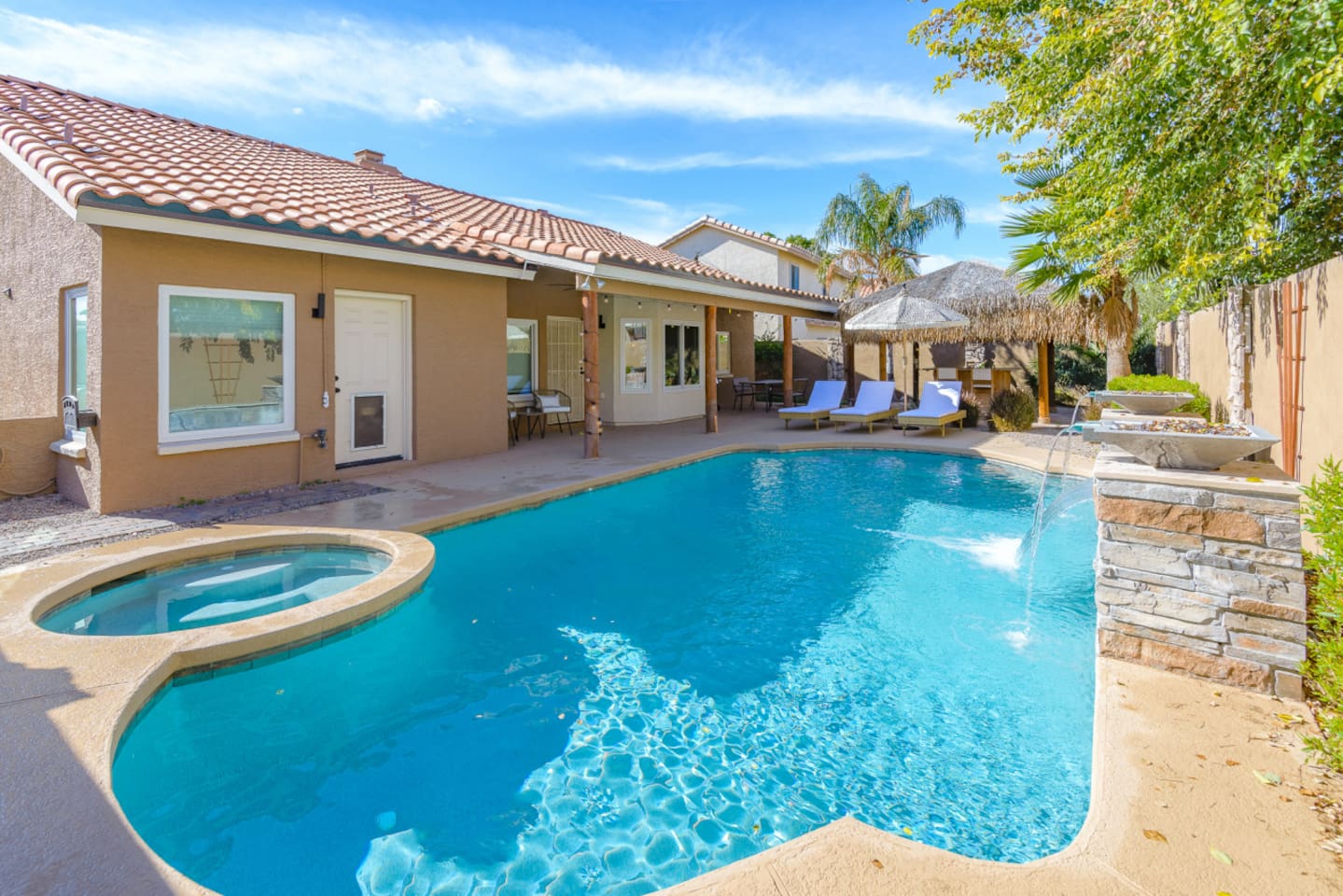 Backyard pool and spa with lounge chairs, water features, and space to enjoy the Arizona sun.