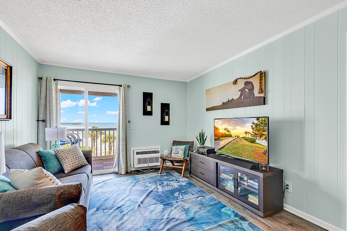 Living Room – Bright and airy with ocean views through the balcony doors
