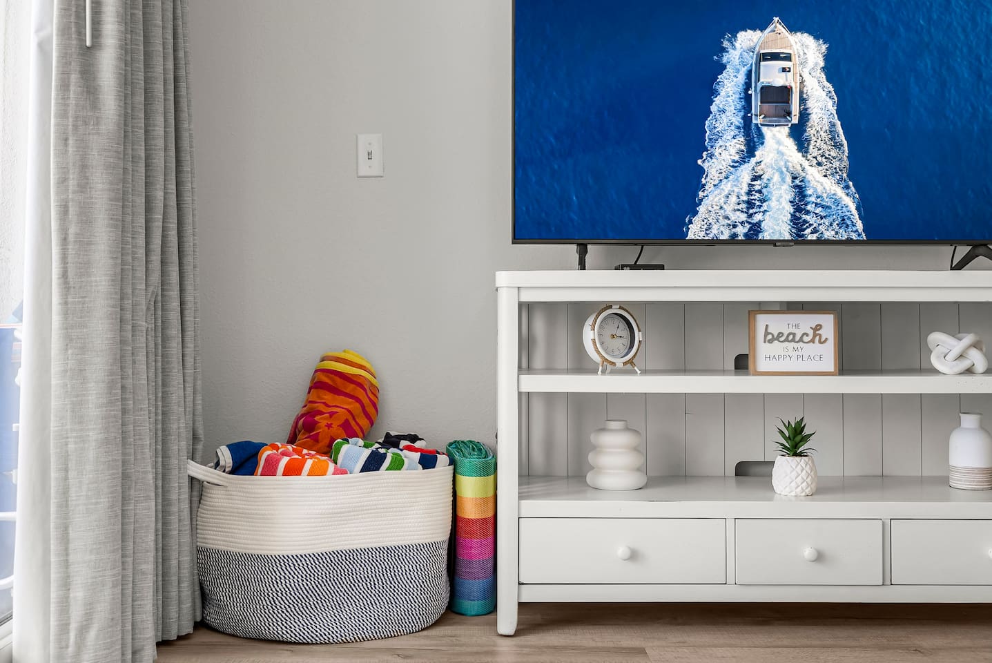 Beach vibes await! Enjoy cozy coastal decor, a smart TV for relaxing nights in, and a basket stocked with colorful beach towels—ready for your next sun-soaked adventure.