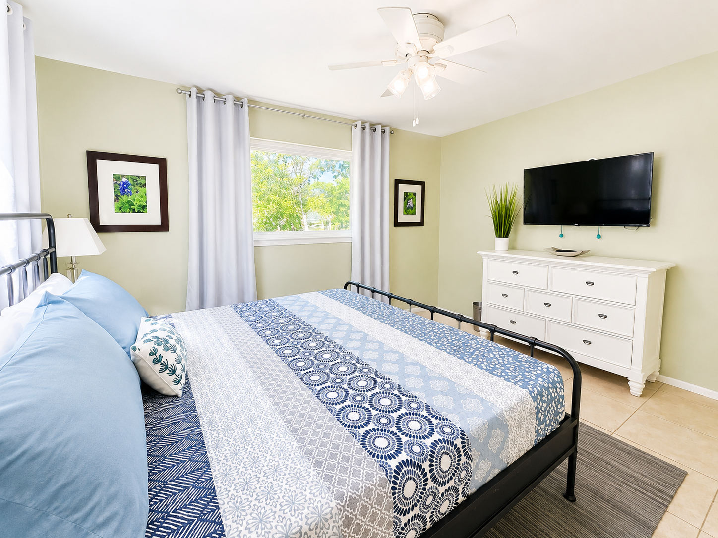King bedroom with smart TV, darkening curtains, and lake view