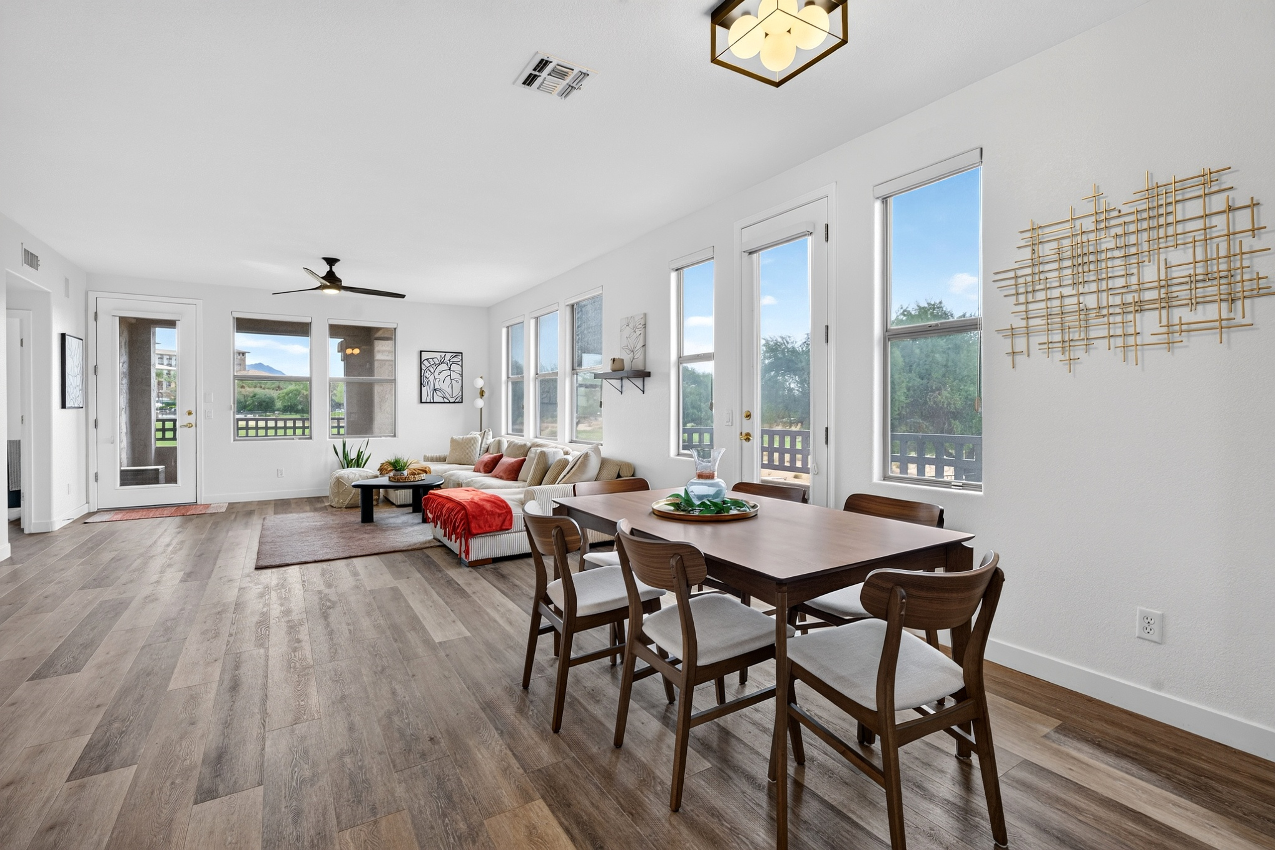 Open living and dining area with table seating, bright windows, and easy flow into the lounge space.