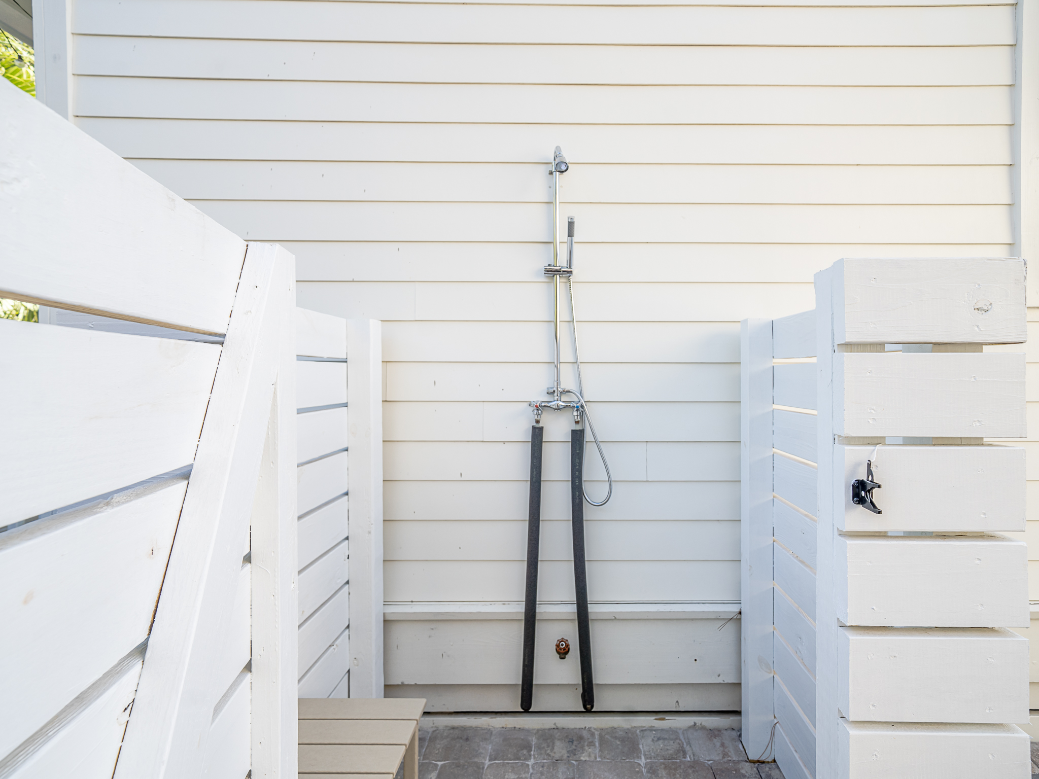 Enjoy an outdoor shower with hot & cold water and a pavered floor