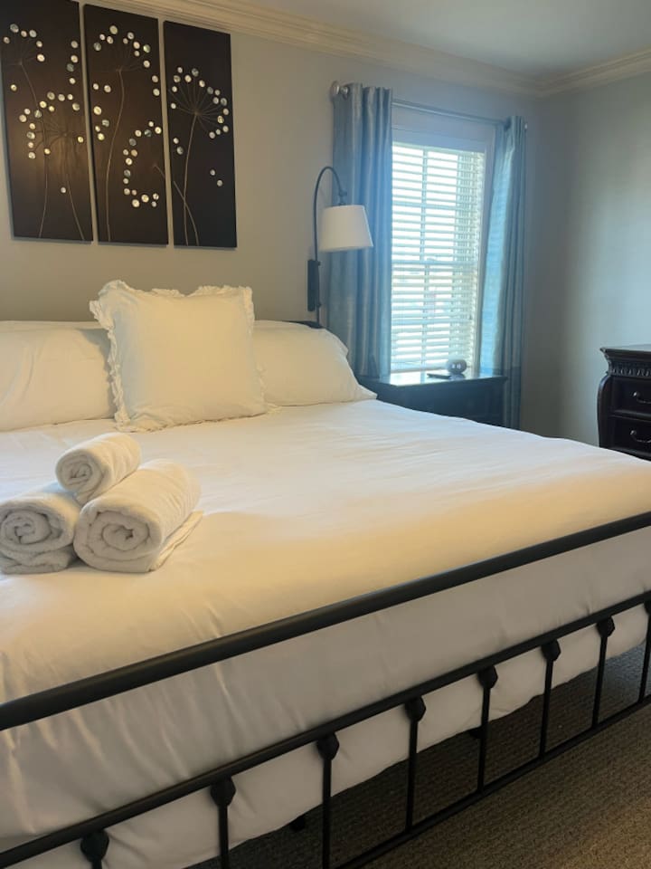 Spacious bed with a comfortable mattress and soft linens, providing the perfect retreat for a restful night’s sleep.