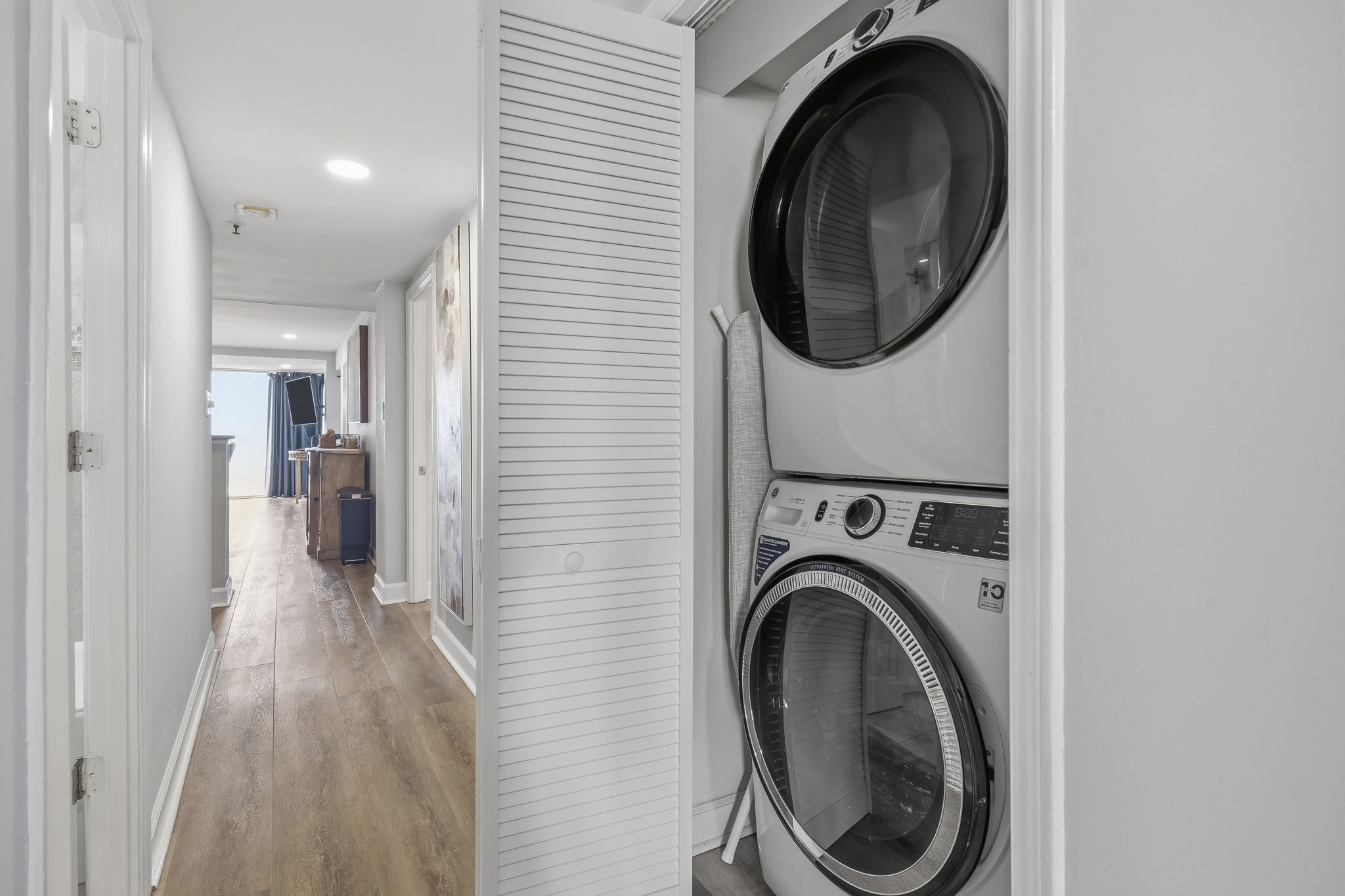 Hallway laundry closet with stacked washer and dryer