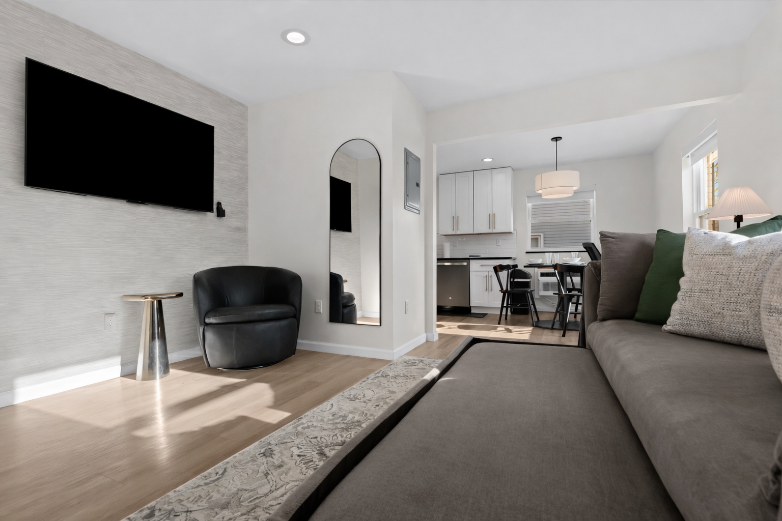Open, modern living space with a pull-out sofa, smart TV, and stylish seating—perfect for relaxing, entertaining, or hosting additional guests.