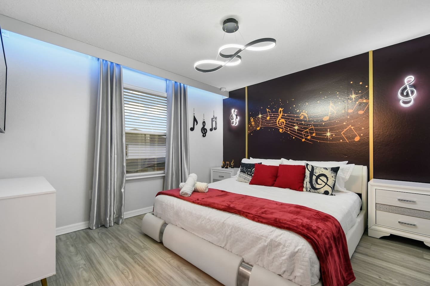 A king-sized bedroom with musical decor, complete with an en suite bathroom that includes a stand-up shower and a smart TV.