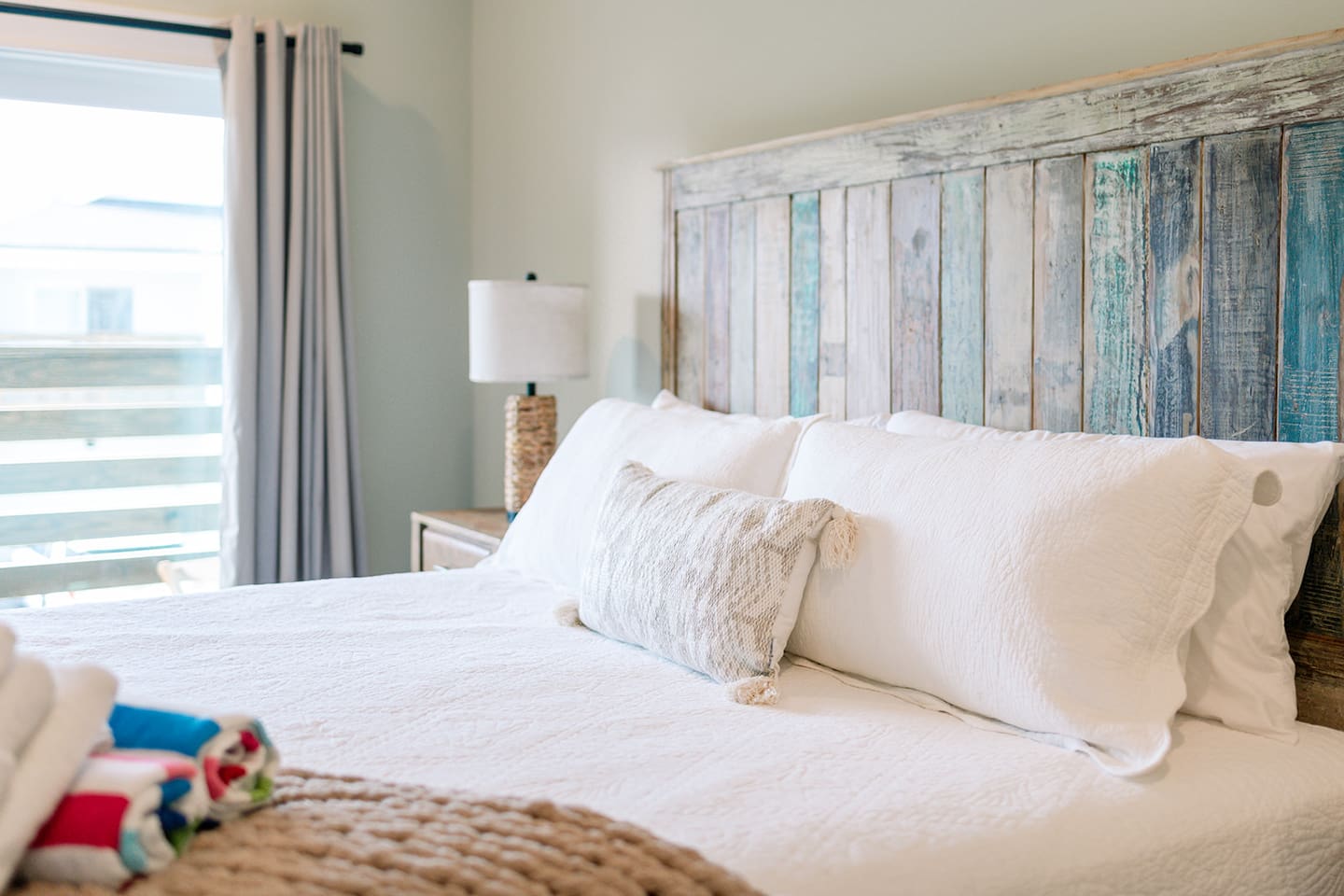 Comfortable king bedroom featuring soft coastal tones and natural light.