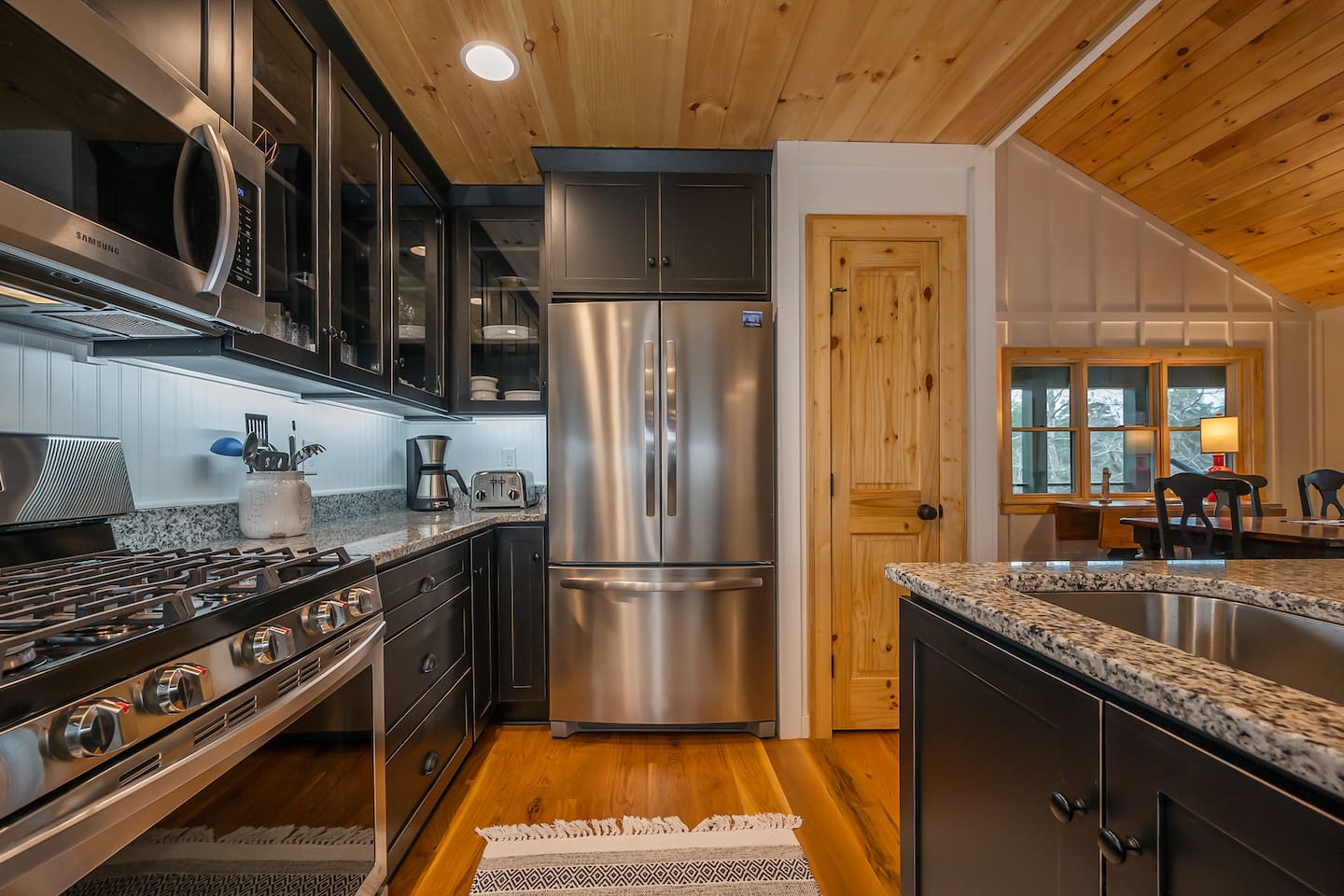 Upgraded kitchen area with stainless steal appliances and seating area