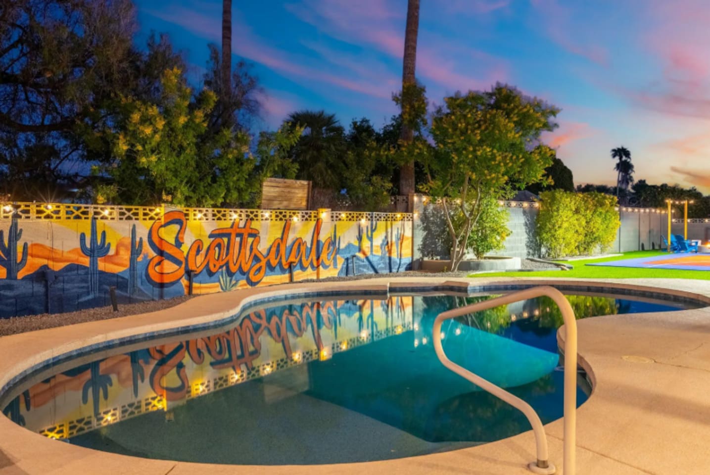 As the sun sets, the pool glows under string lights with a hand-painted Scottsdale mural setting the backdrop for evening swims.
