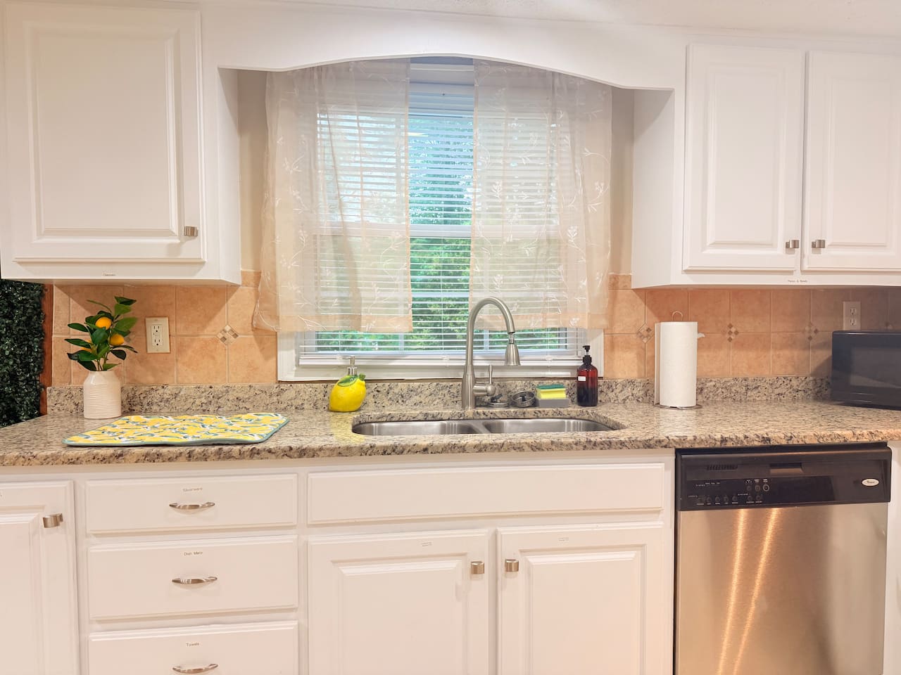 Large sink with window view adds brightness and a fresh feel to the kitchen’s prep and clean-up area. 