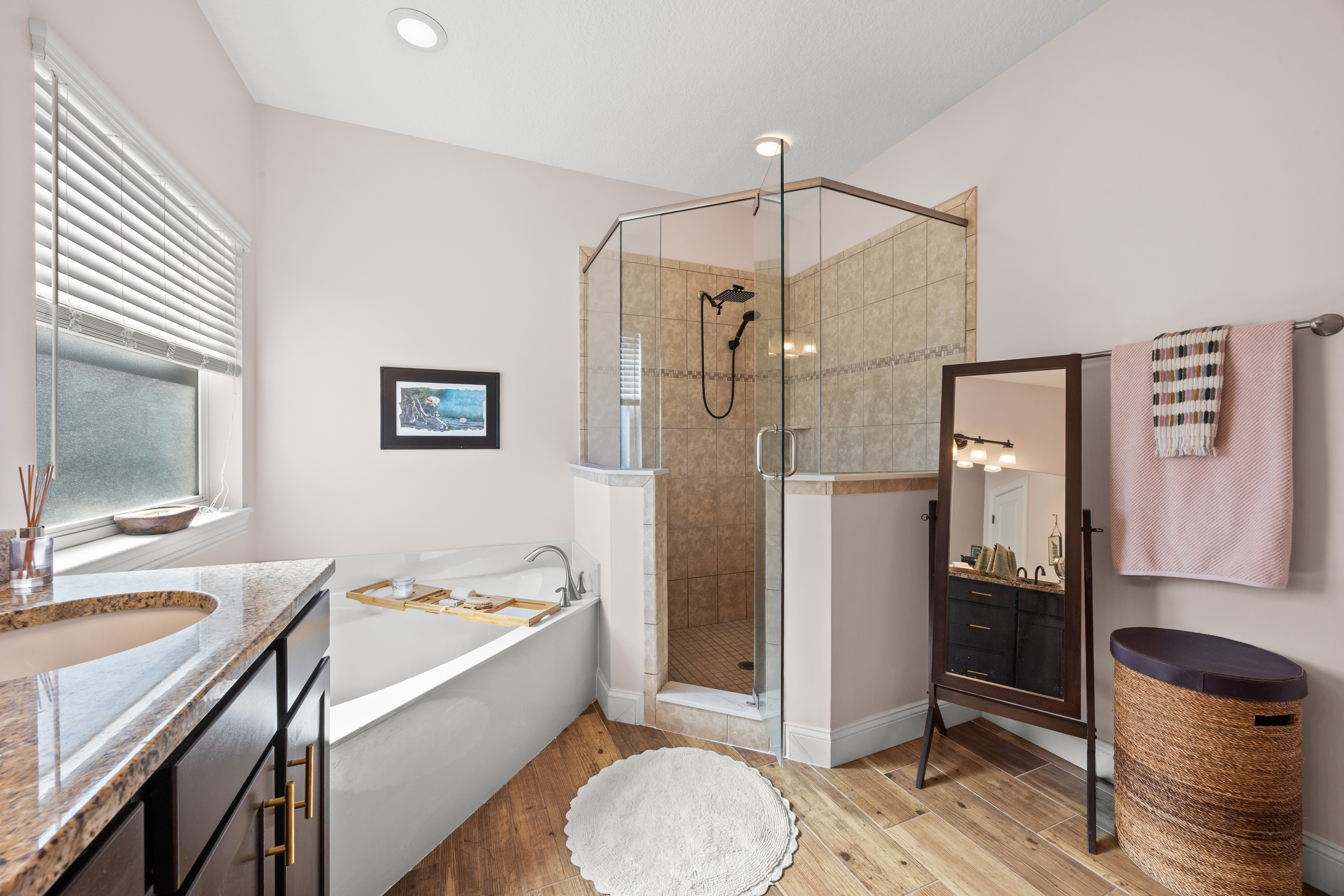 Spacious bathroom with double‑sink vanity, soaking tub, and glass shower in upscale Jacksonville Beach vacation rental.