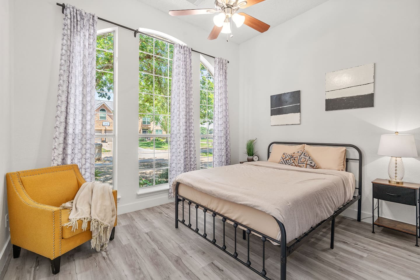 Comfortable bedroom with queen bed, room darkening shades, sitting area, and modern decor.