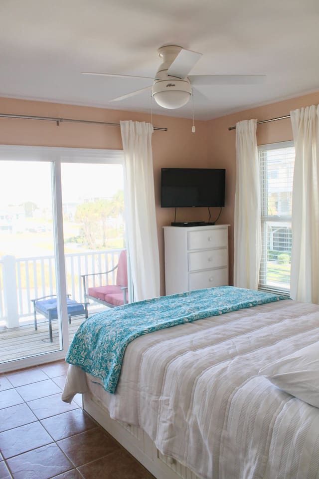 2nd floor guest bedroom #1. Back of house. Balcony access. Queen bed. TV. Closet + dresser for clothes.