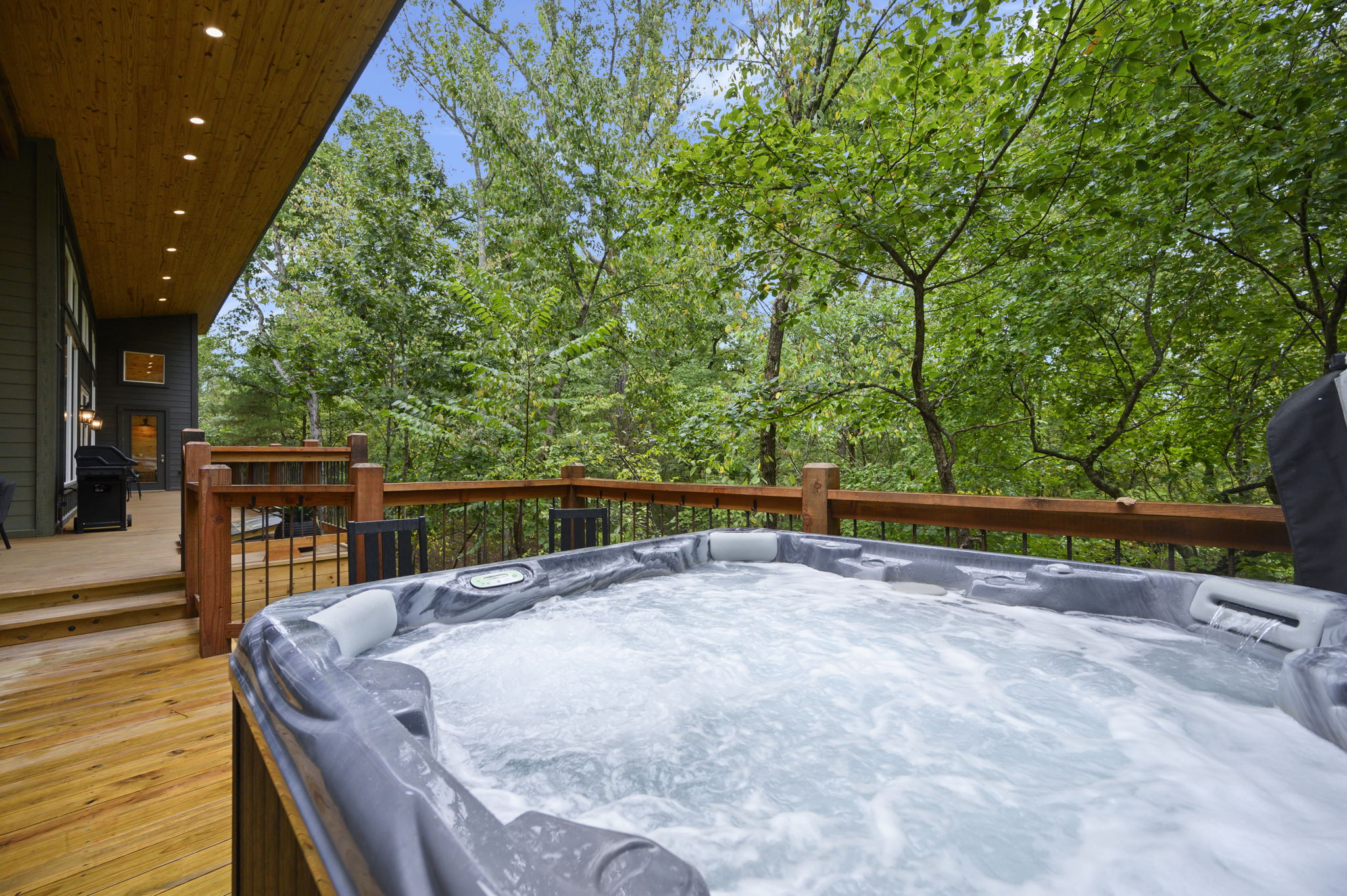 Private hot tub on the wooded deck at Stay Rooted.