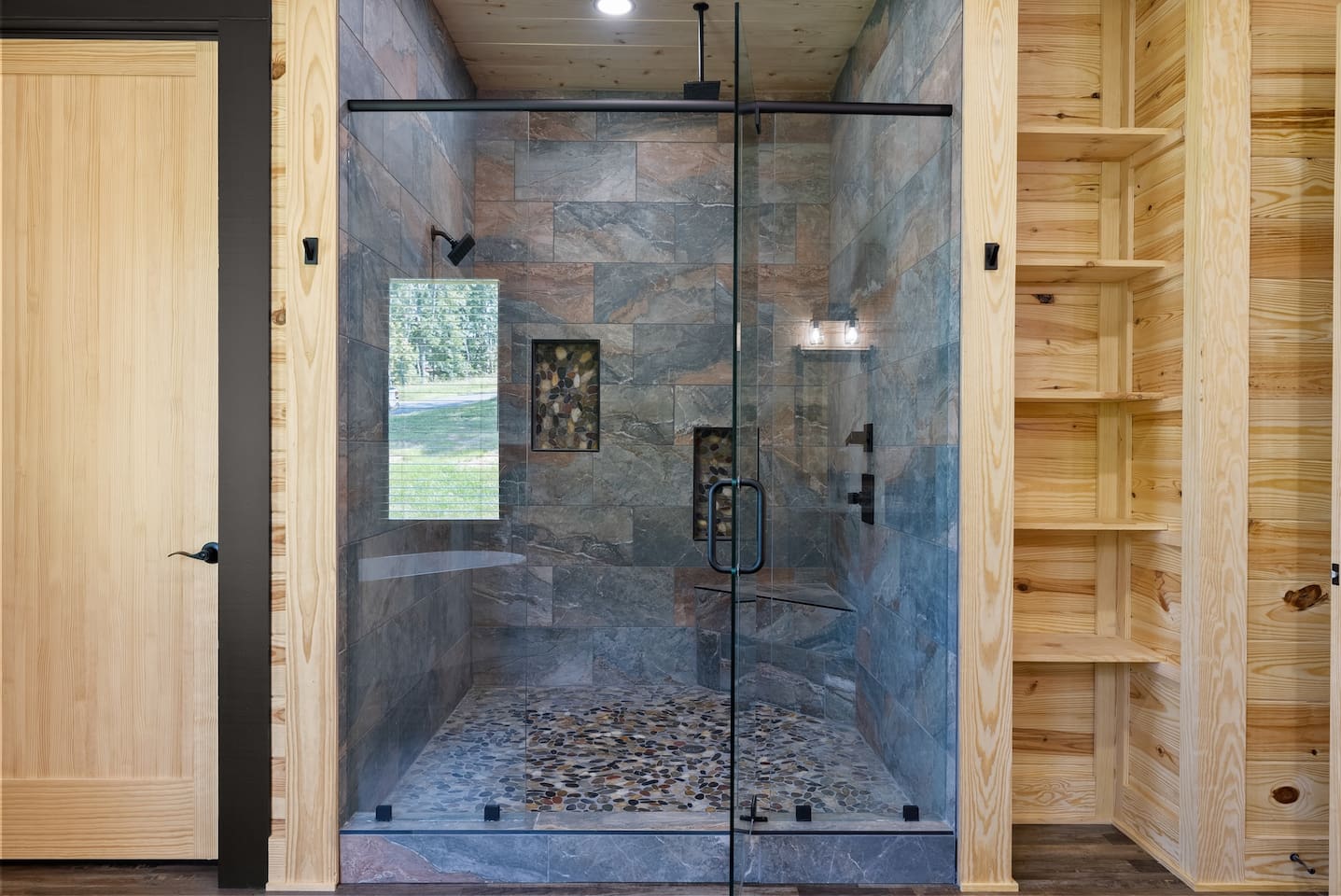 Refresh in style in this oversized glass walk-in shower with natural stone tile and rainfall showerhead.

