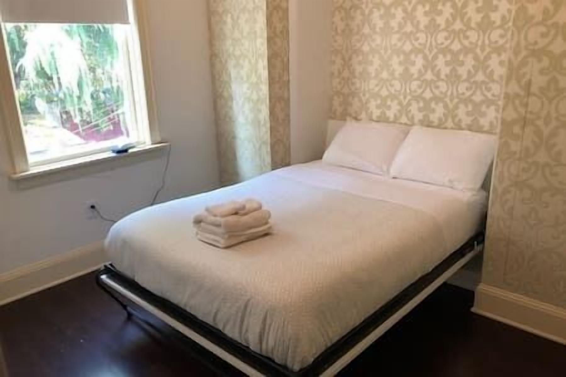 This serene guest room features a cozy queen bed, a peaceful view of the private rear patio, and a 32" Roku Smart TV for relaxed streaming anytime.