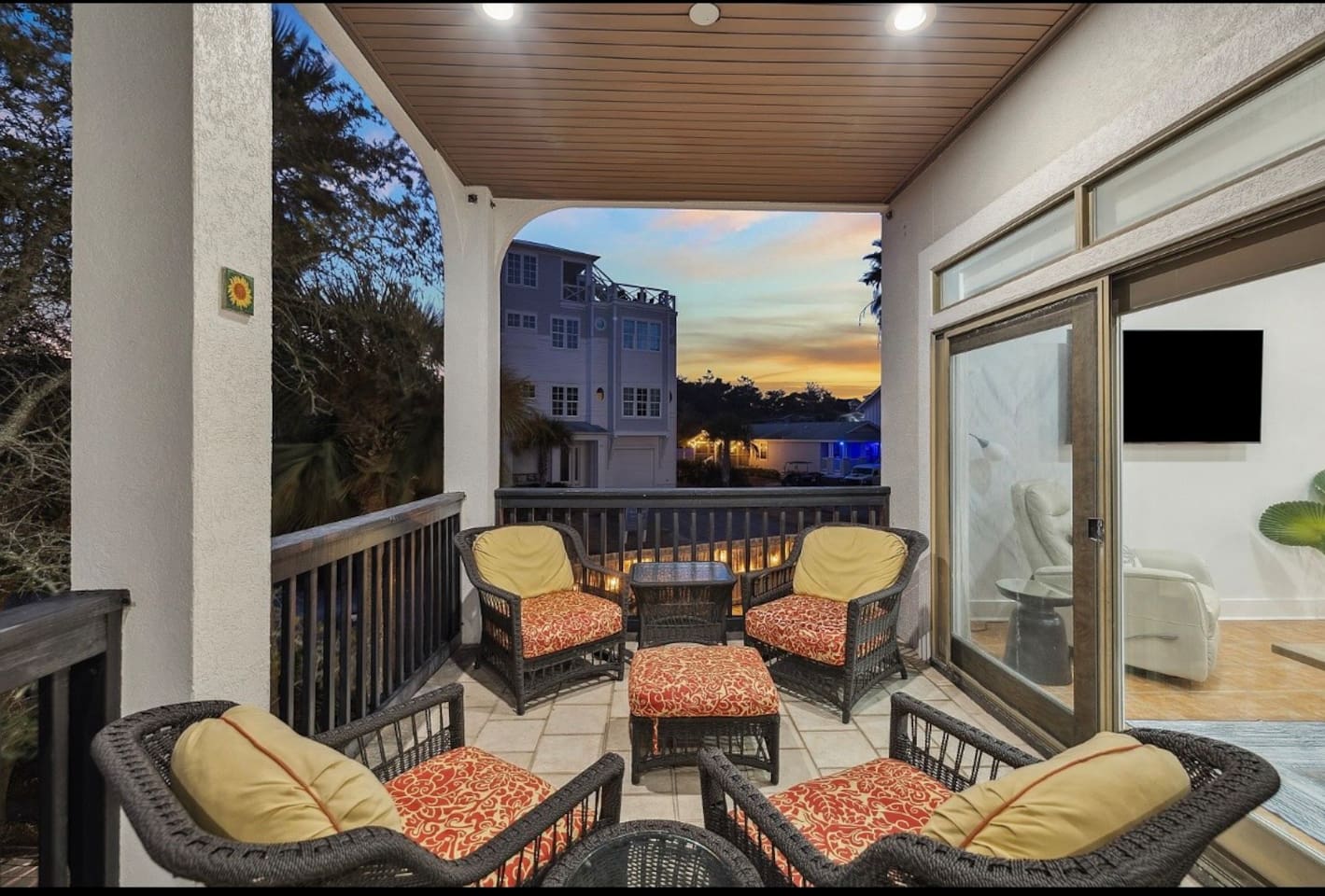 Expansive covered main-level balcony equipped with cozy outdoor furnishings, providing a perfect open-air gathering spot to enjoy the coastal breeze