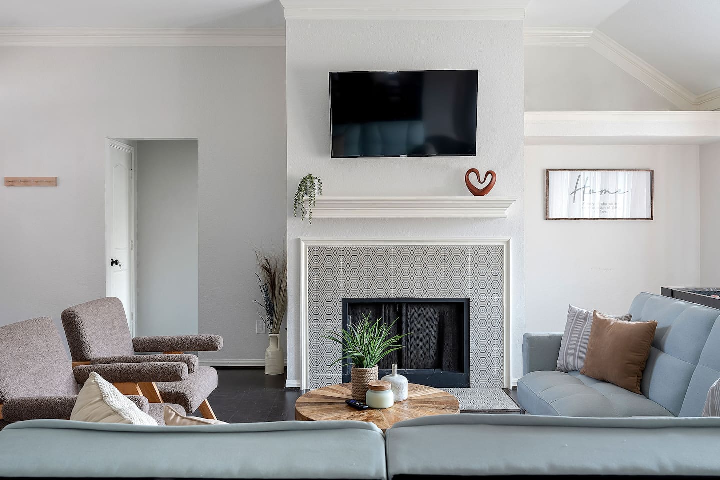 Welcome to our inviting living space with cozy sofas and a sleek TV setup. Shaded windows bring in just the right amount of natural light, creating a perfect balance of comfort and ambiance.