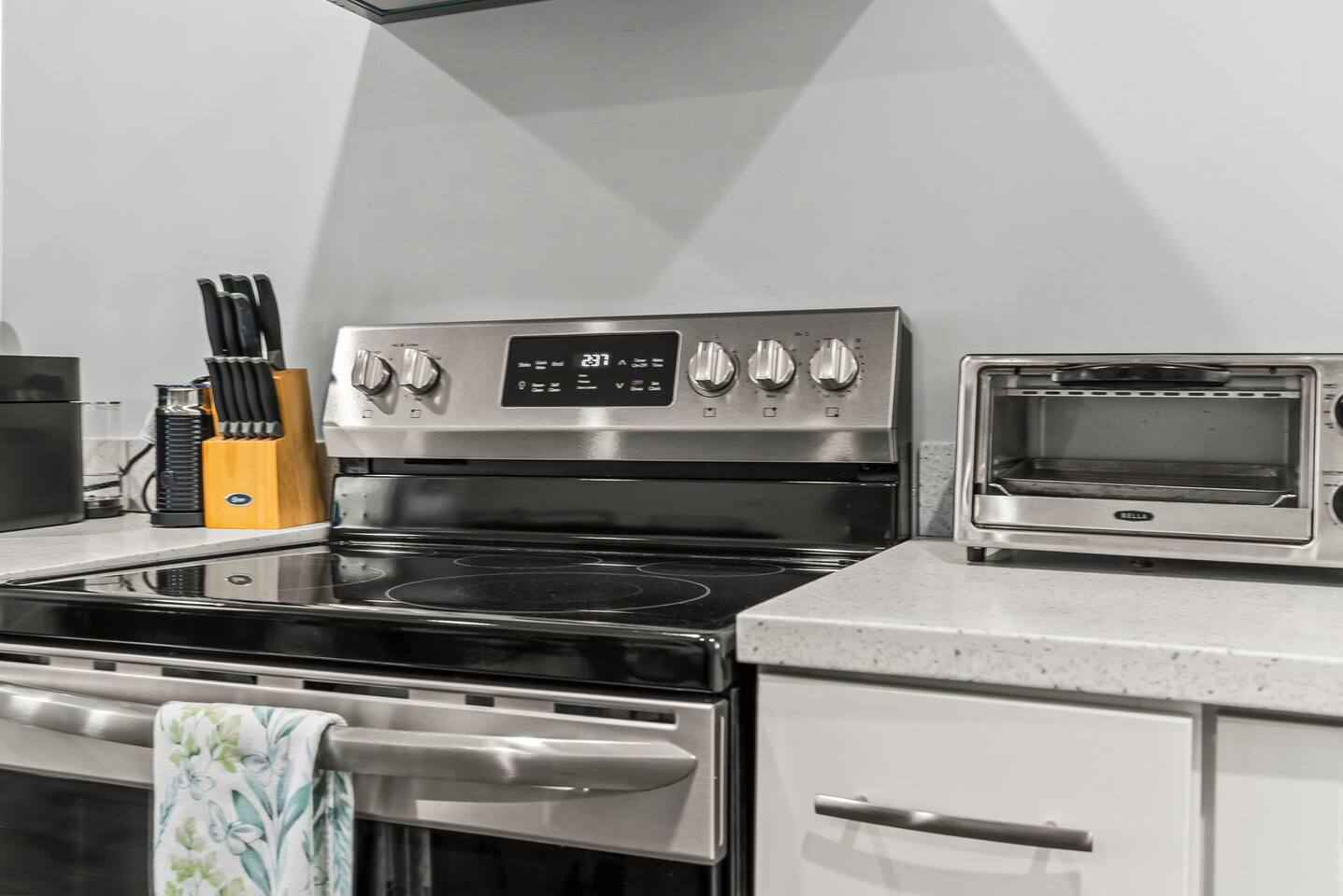 Close-up of the cooking zone with updated appliances, clean countertops, and thoughtful kitchen essentials.