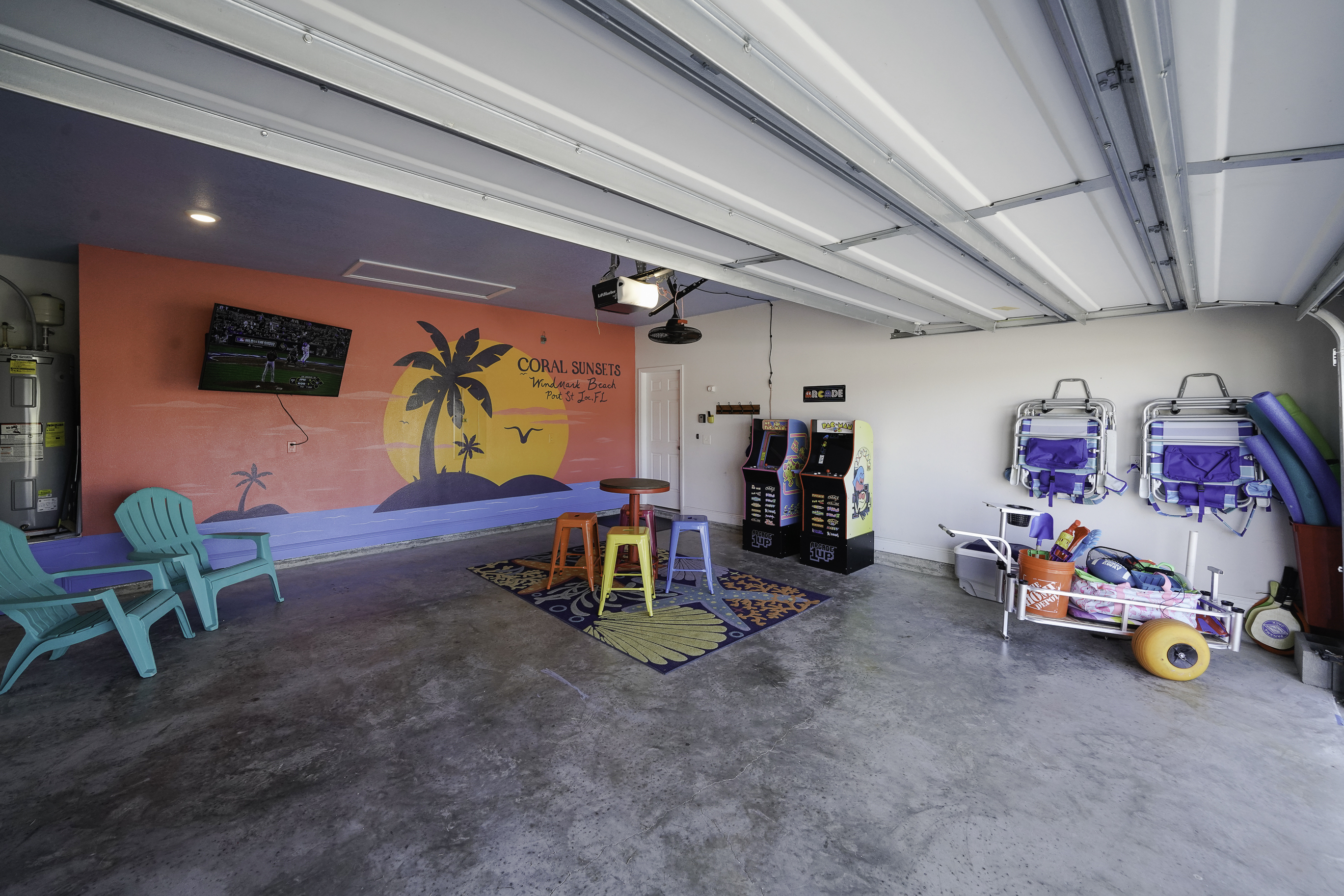 Spacious garage with bikes, TV, arcade, golf cart, and beach gear.