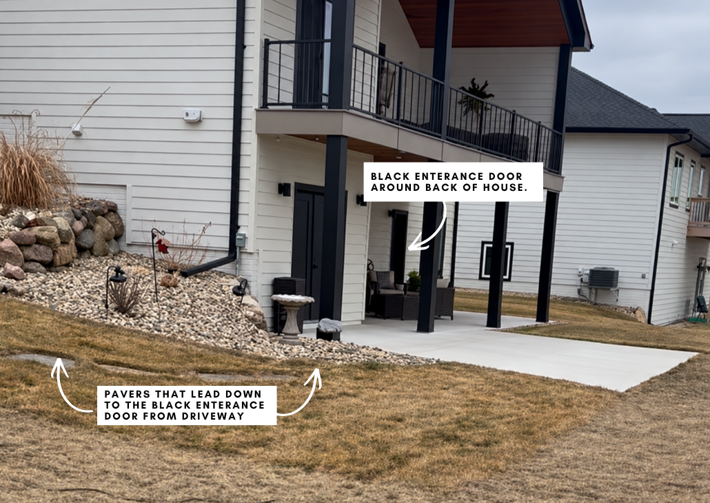 There are pavers (not a sidewalk) that leads from the driveway down to the patio area by the black entrance door.