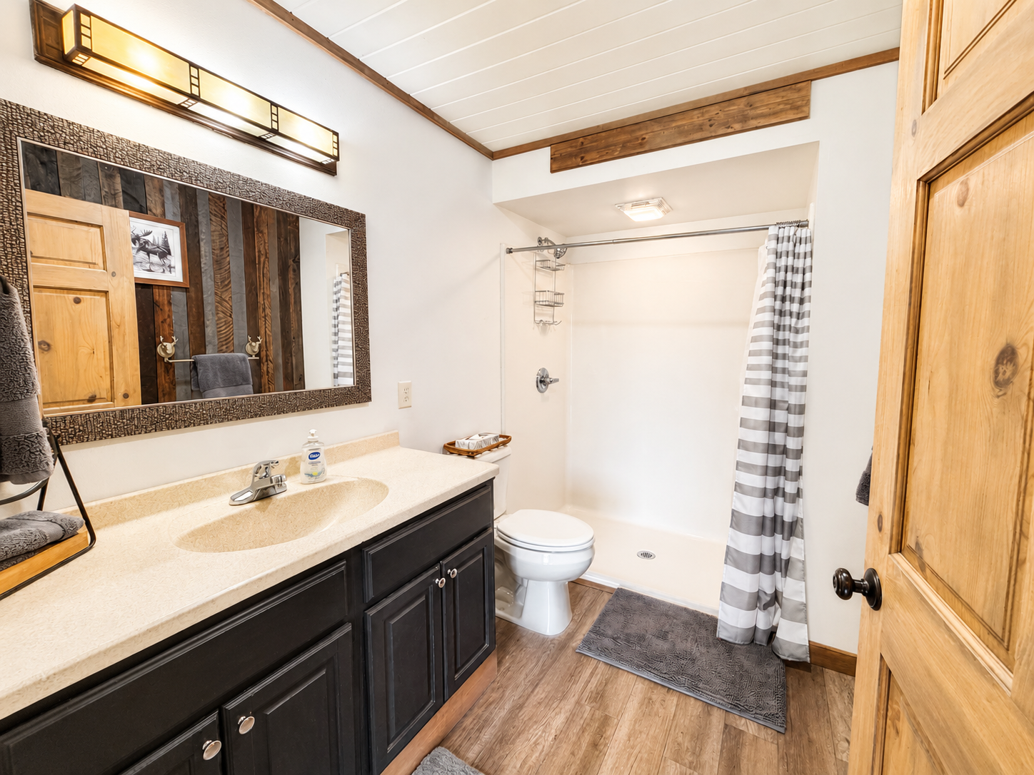 Full bathroom with a spacious vanity, shower and tub combination, and plenty of room to get ready, adding convenience for families and larger groups sharing the lodge. Conveniently located right off the kitchen and living room.
