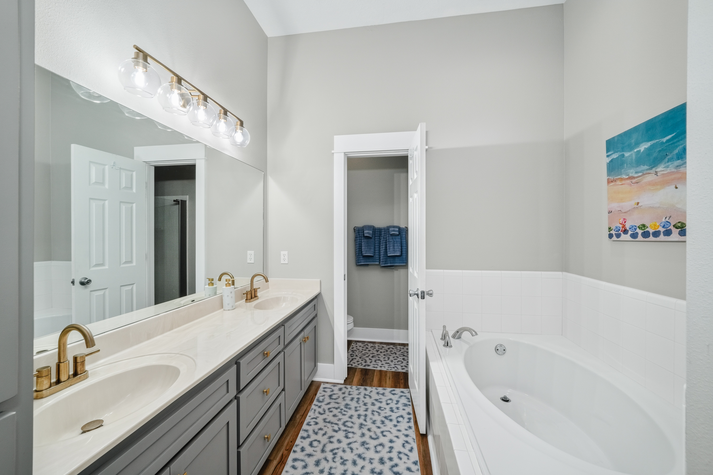 en-suite bathroom with dual vanities and a full soaking tub, offering extra space and convenience for a comfortable and relaxing day