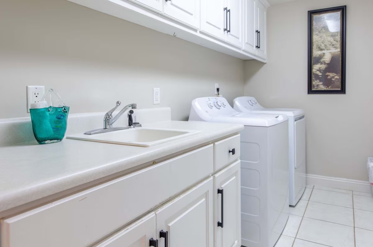 Spacious Laundry Room With Washer, Dryer, Utility Sink, and Ironing Board