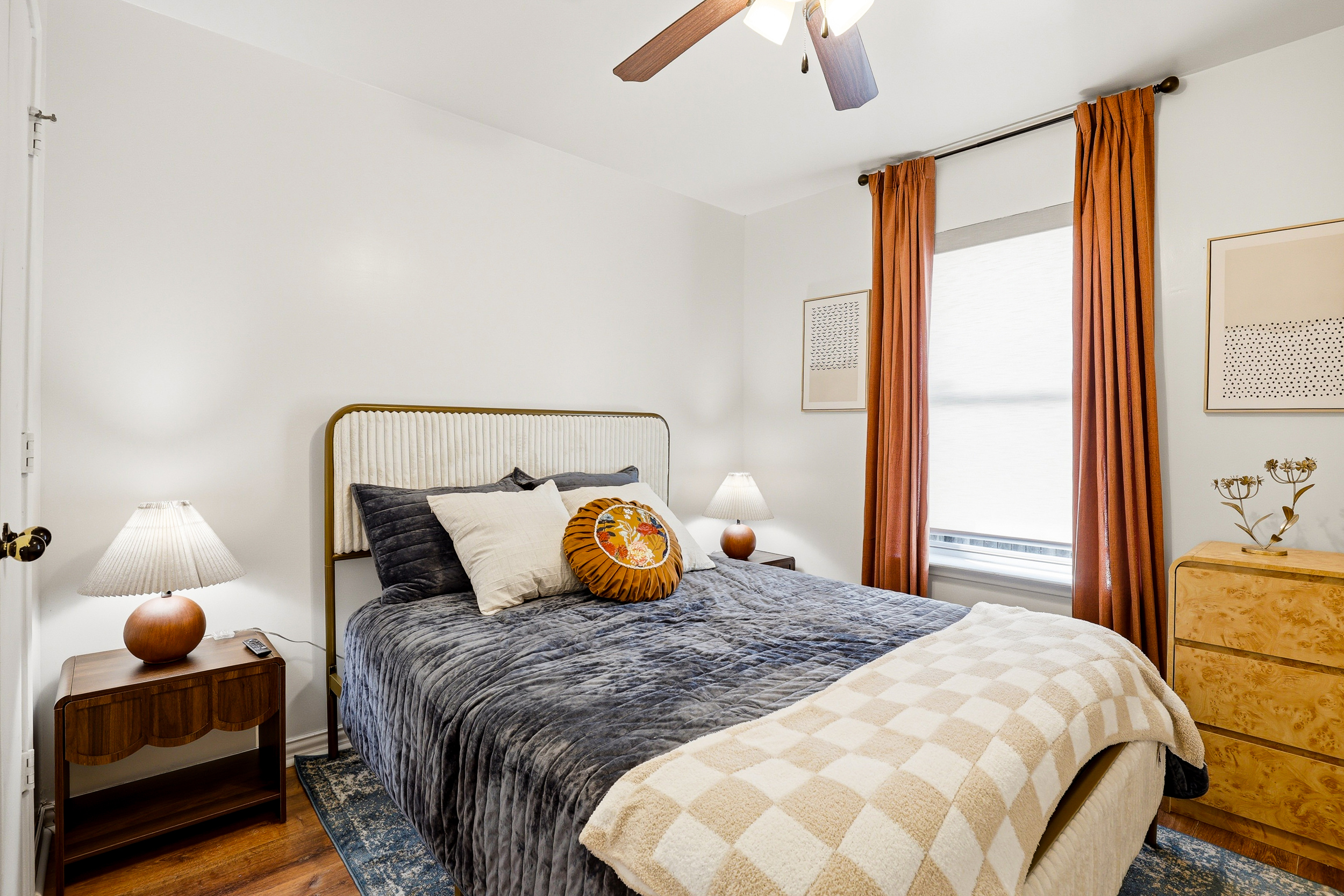 Queen bedroom showing wall-mounted Smart TV, ceiling fan, full closet with double doors, and lock on the bedroom door. Everything you need for a comfortable, private night's rest.