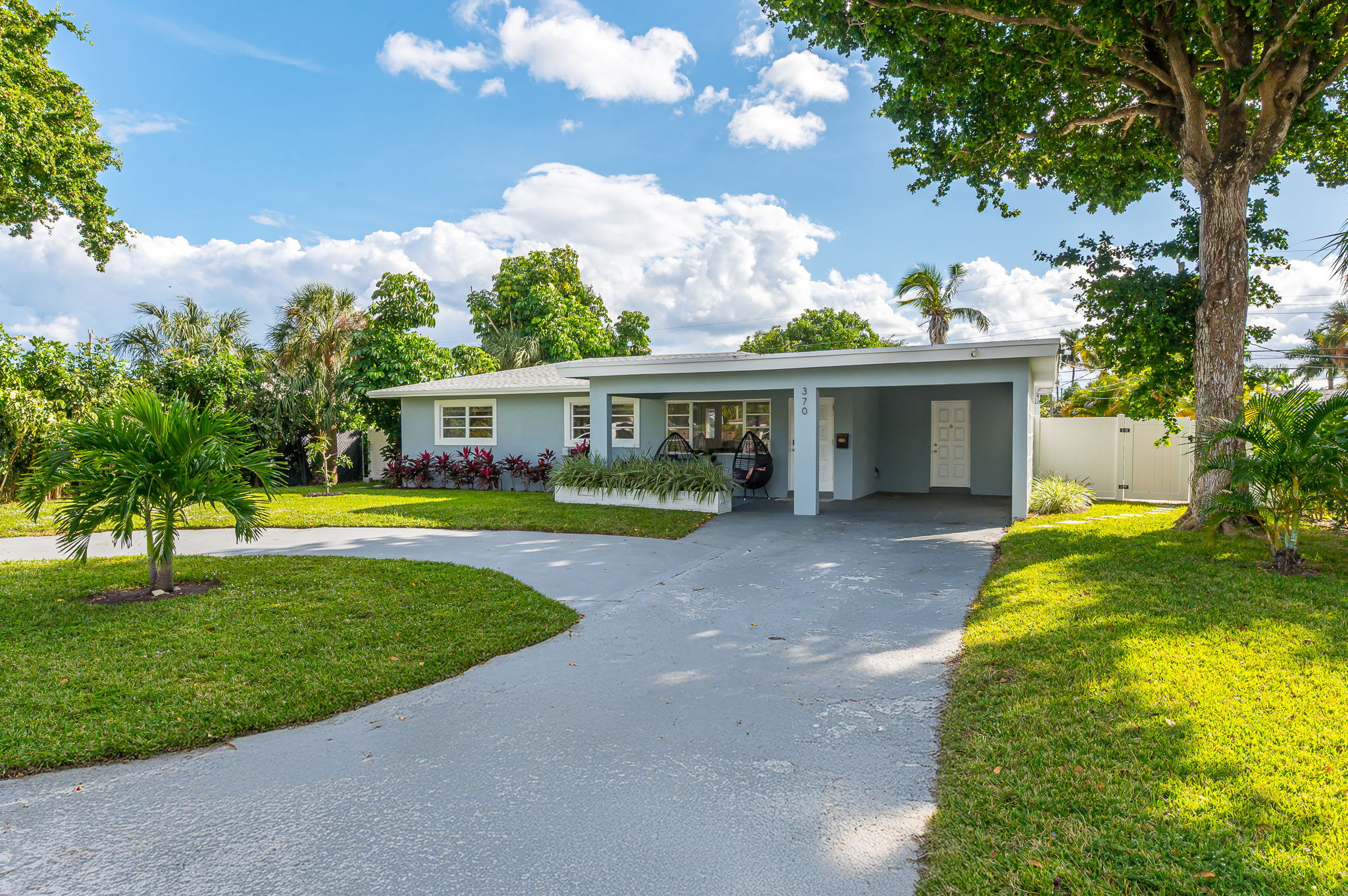 Welcome to your private Pompano Beach retreat—lush landscaping, a spacious circular driveway, and bright coastal charm from the moment you arrive.