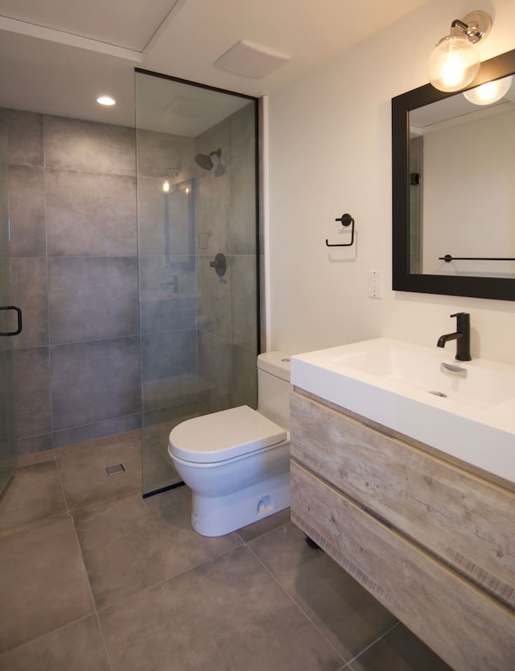 Fourth Bathroom: Modern shower and sink drawer for personal use.
