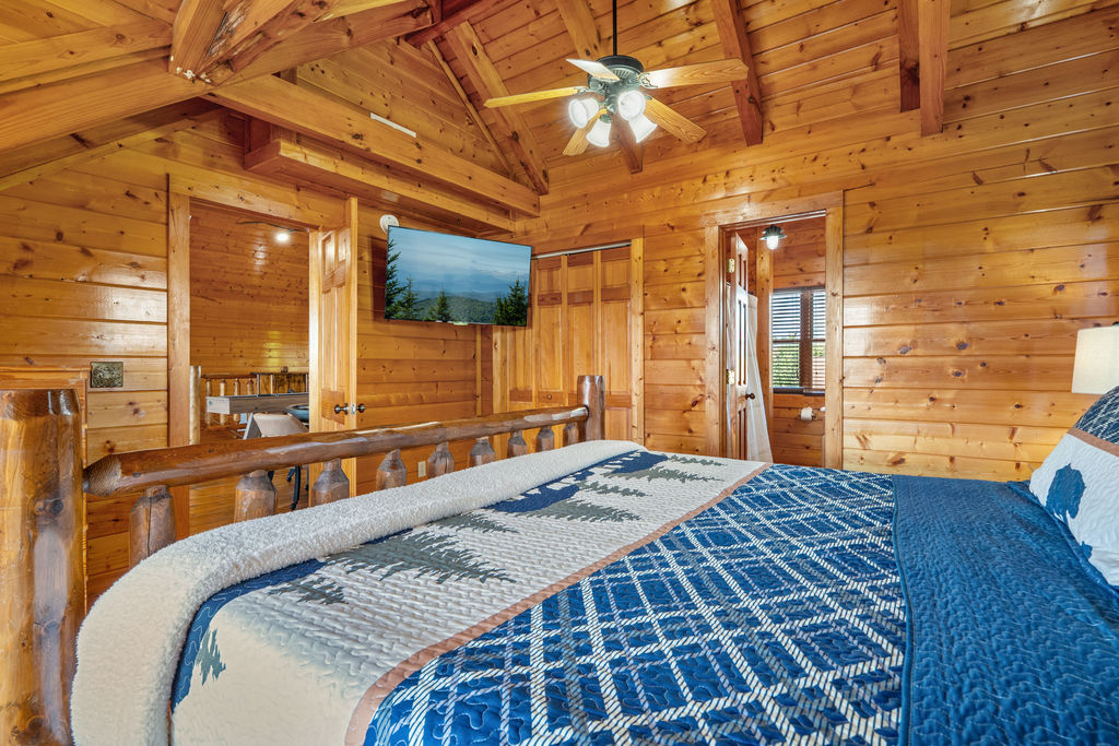 This king bedroom exudes cozy mountain charm with warm tones, wilderness-inspired d&eacute;cor, and plush bedding&mdash;your perfect retreat after a day in the Smokies.