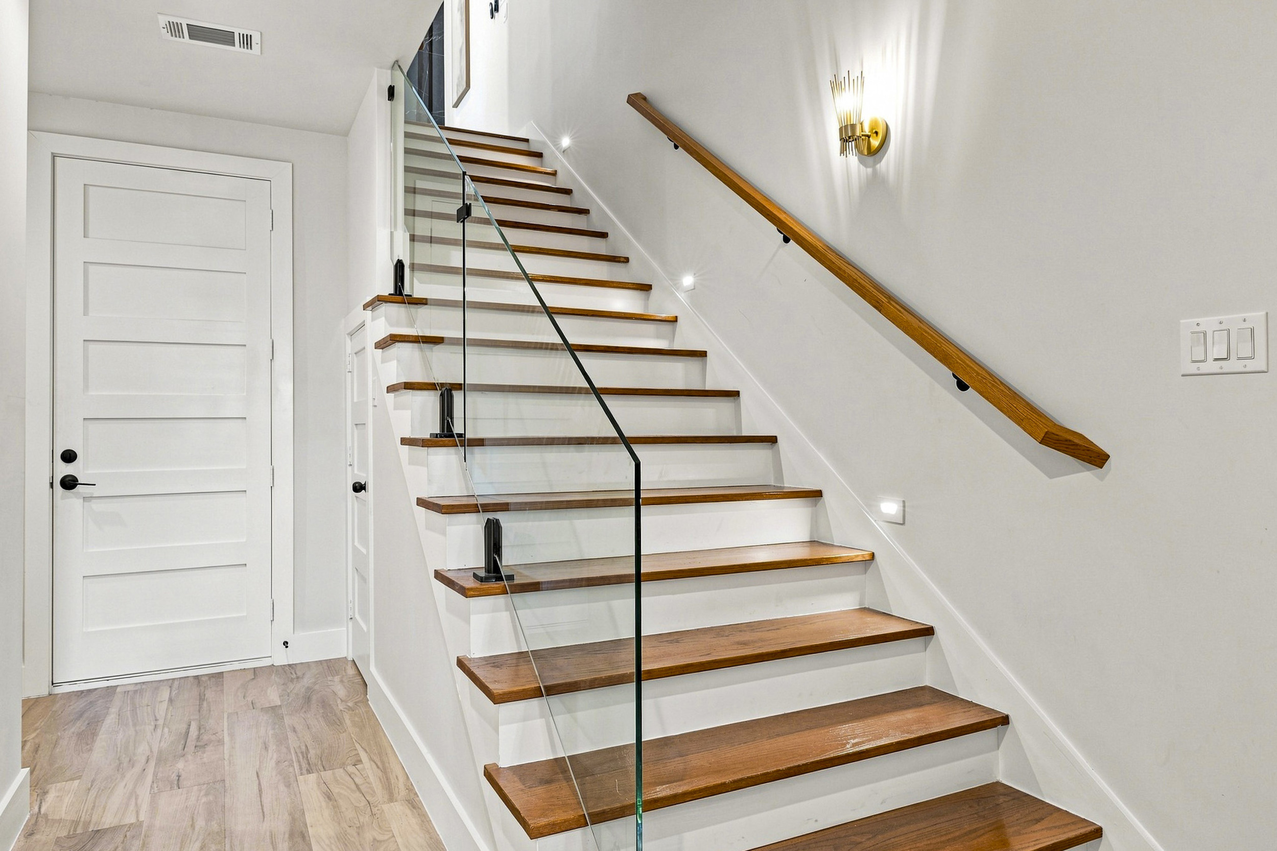 Ascend to elegance with sleek glass railings and stylish lighting!