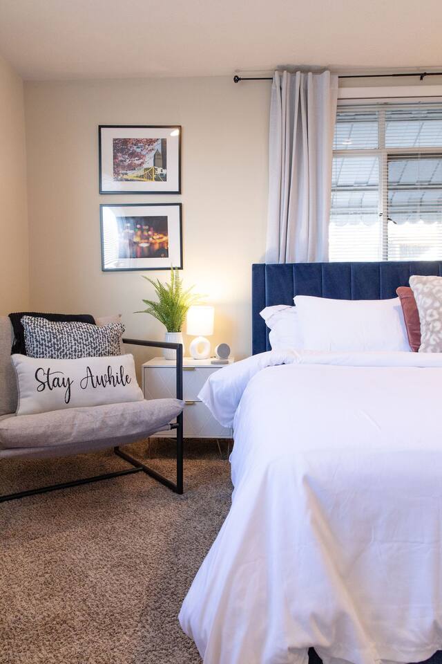 Cozy, spacious room with a queen-sized bed, TV, and a dedicated working space.