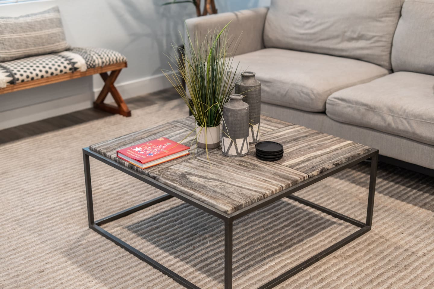 Relax in style with this inviting living room, featuring a minimalist glass TV stand and beautiful indoor greenery.