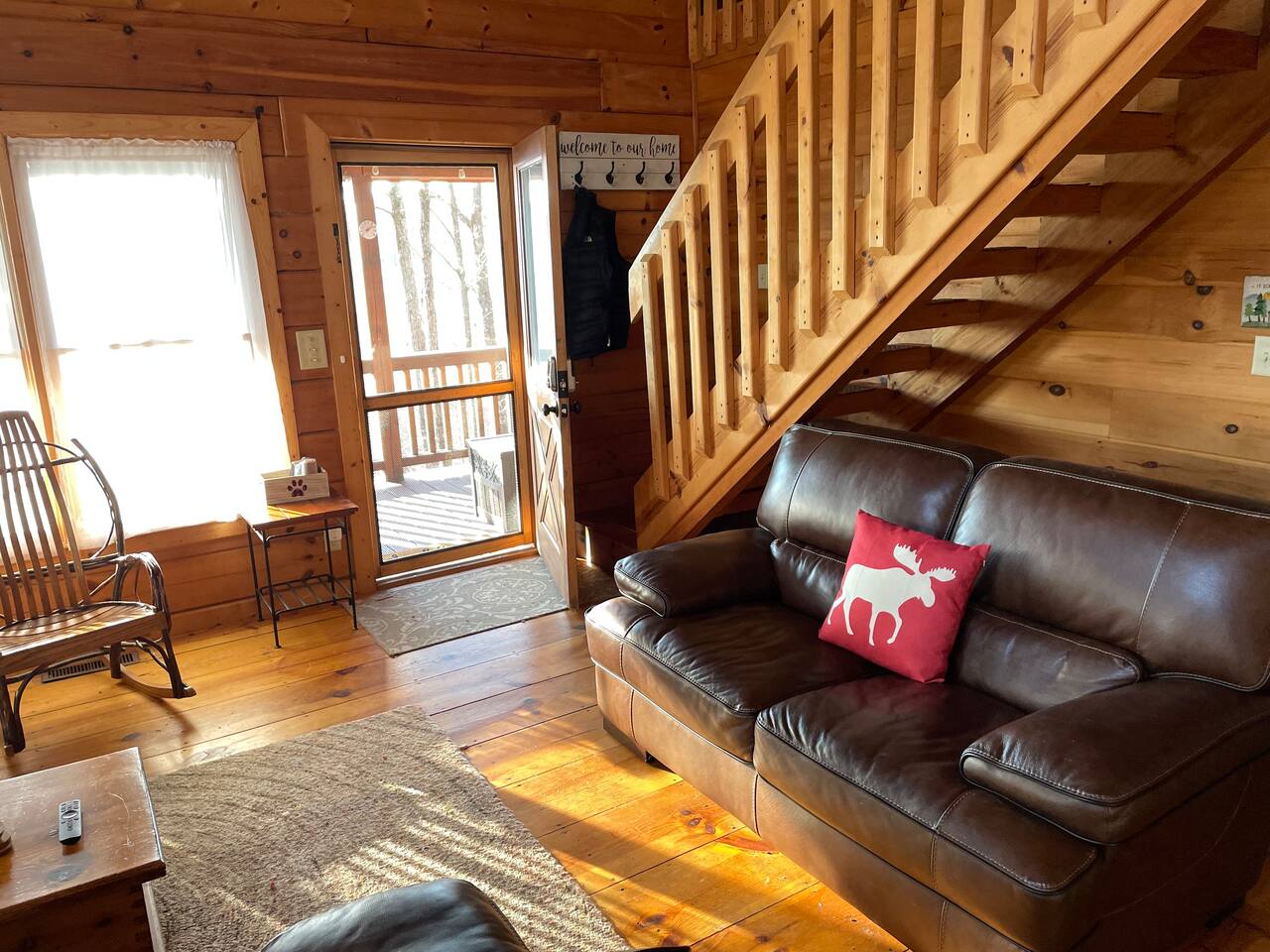 Leather couches in the living room with with large TV and nice view of mountains outside.