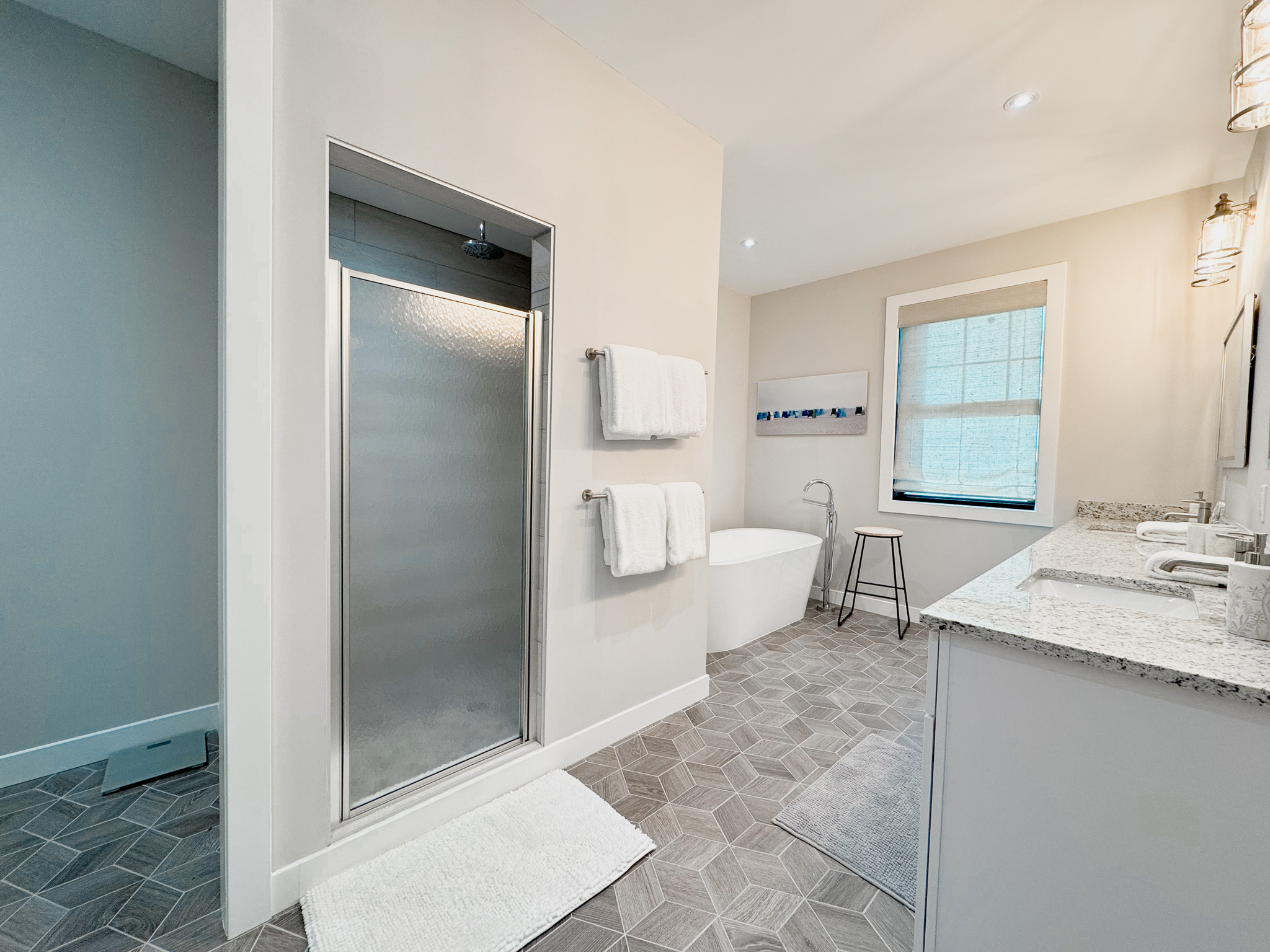 Spacious primary bathroom with tub and walk in shower.