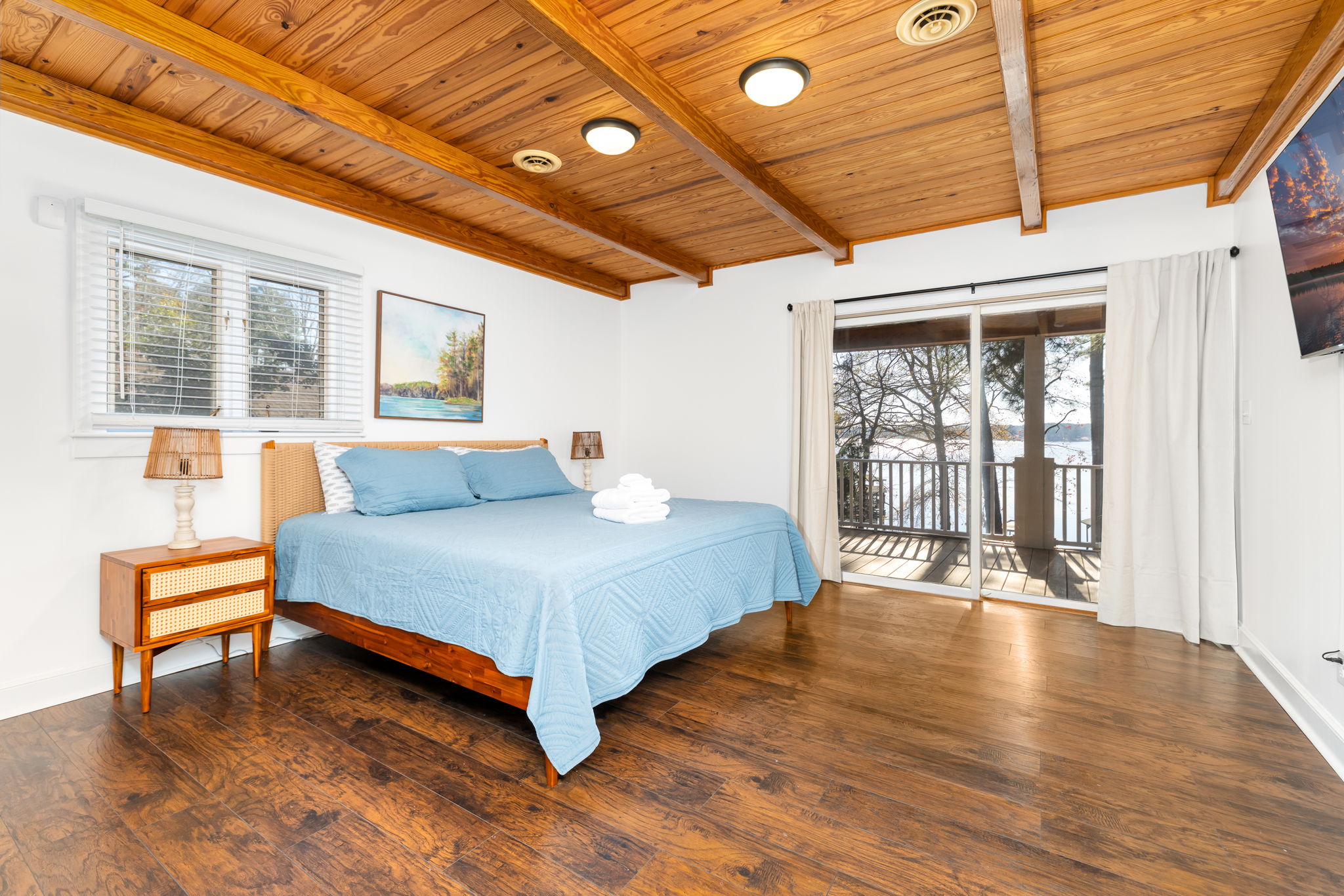 Wake up to lake views in this comfortable king bed master bedroom.