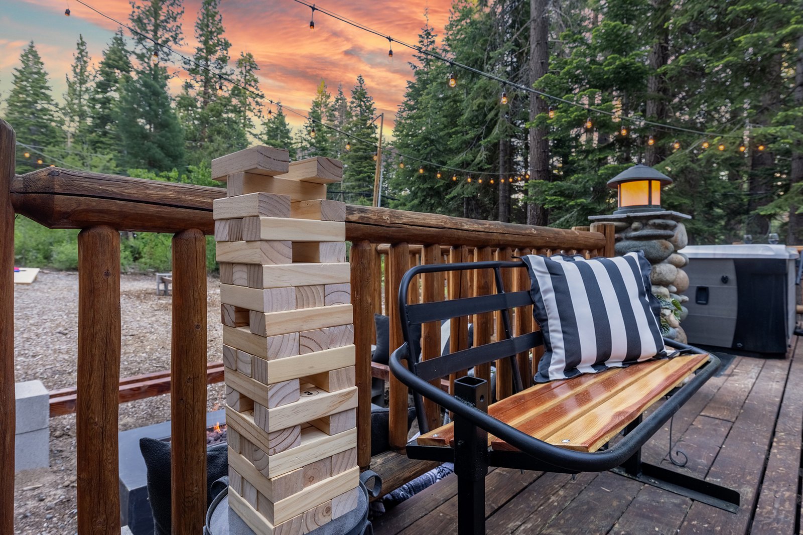 Stack the giant Jenga as high as you dare — the deck turns into game night the second the string lights flick on.
