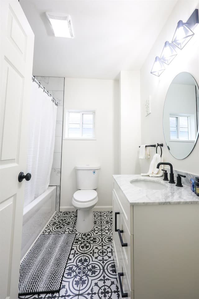 This full bathroom features a shower tub and minimalist design, offering a clean, serene space for relaxation and comfort.
