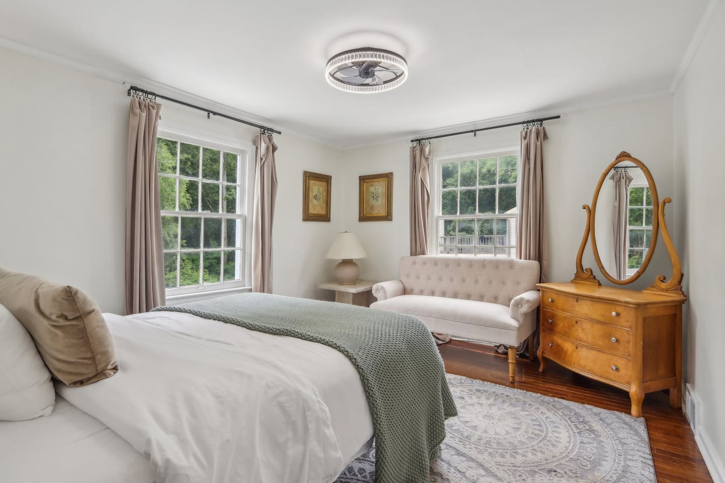 Unwind in this bright bedroom with a pillow-top Queen bed, relaxing couch, vintage vanity, and plenty of storage for a comfortable stay.