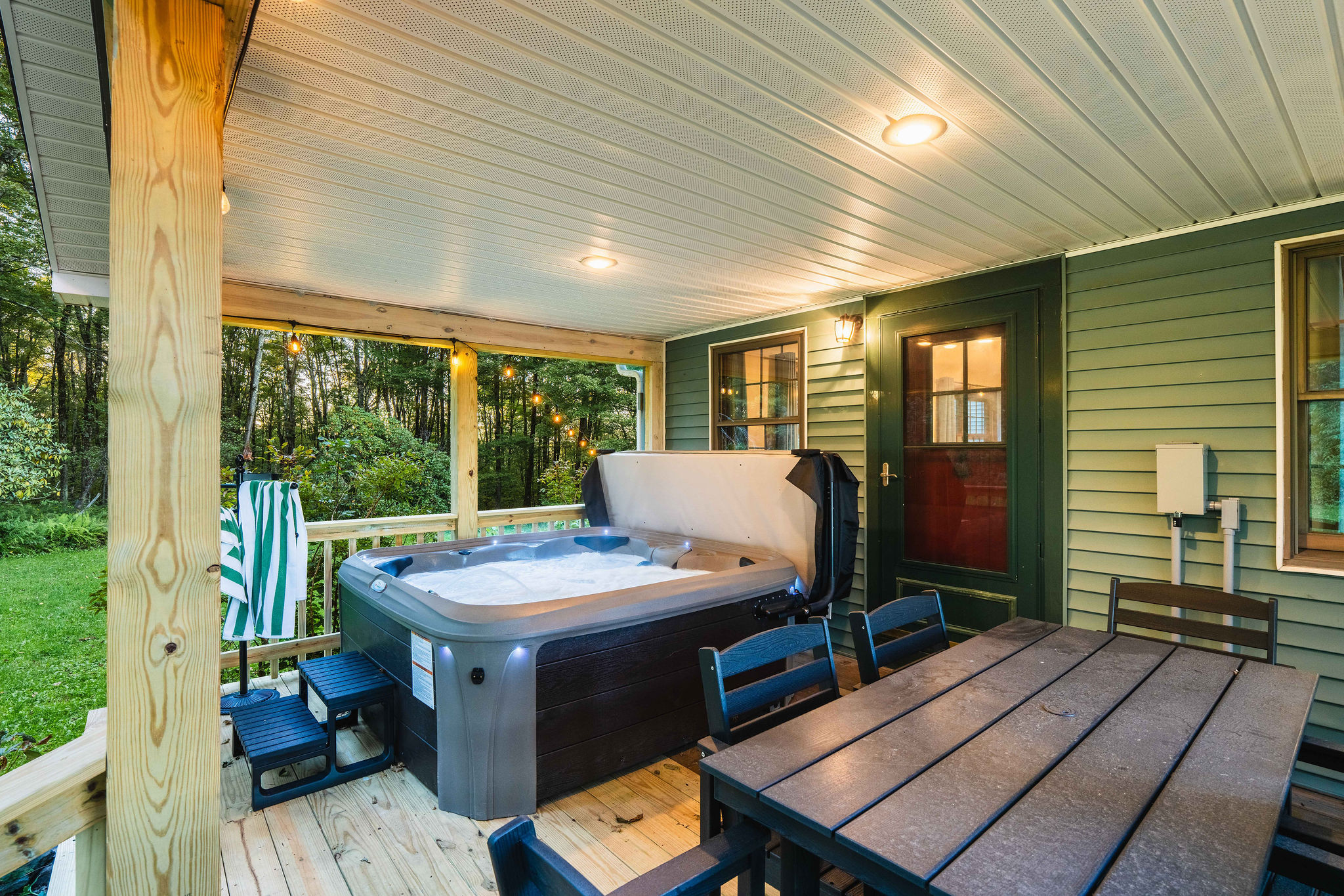 🛁 6-person hot tub on the covered deck — usable in any weather, with outdoor dining for 6 alongside.